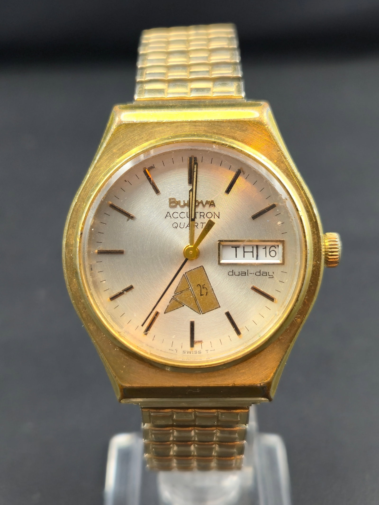 1979 Bulova Accutron Quartz Day-Date Gold Tone 34.1mm Don Remmel Engraved Box Papers: Vintage Bulova Accutron Quartz wristwatch from 1979, featuring a gold-tone case and matching bracelet with a silver sunburst dial. Dial is signed Bulova Accutron Quartz with dual-day (day/date) displa