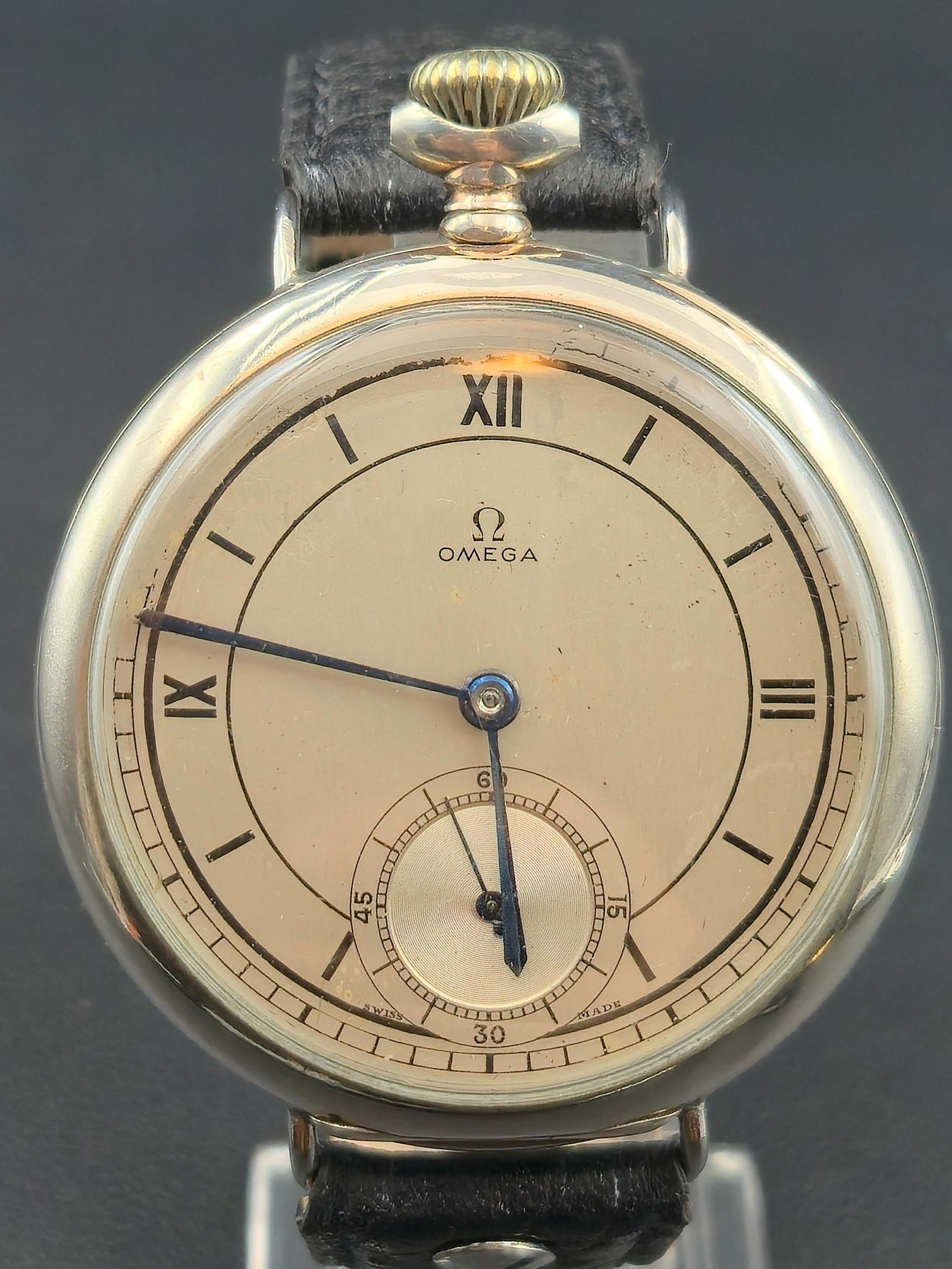 1918 Omega Pocket Watch Conversion 49mm .800 Silver Case Roman Dial Sub Seconds: This circa 1918 Omega Swiss wristwatch features a large 40.0 mm .800 silver case, enamel-style cream dial with Roman numerals, and a recessed sub-seconds register at 6 o’clock. The watch is powered