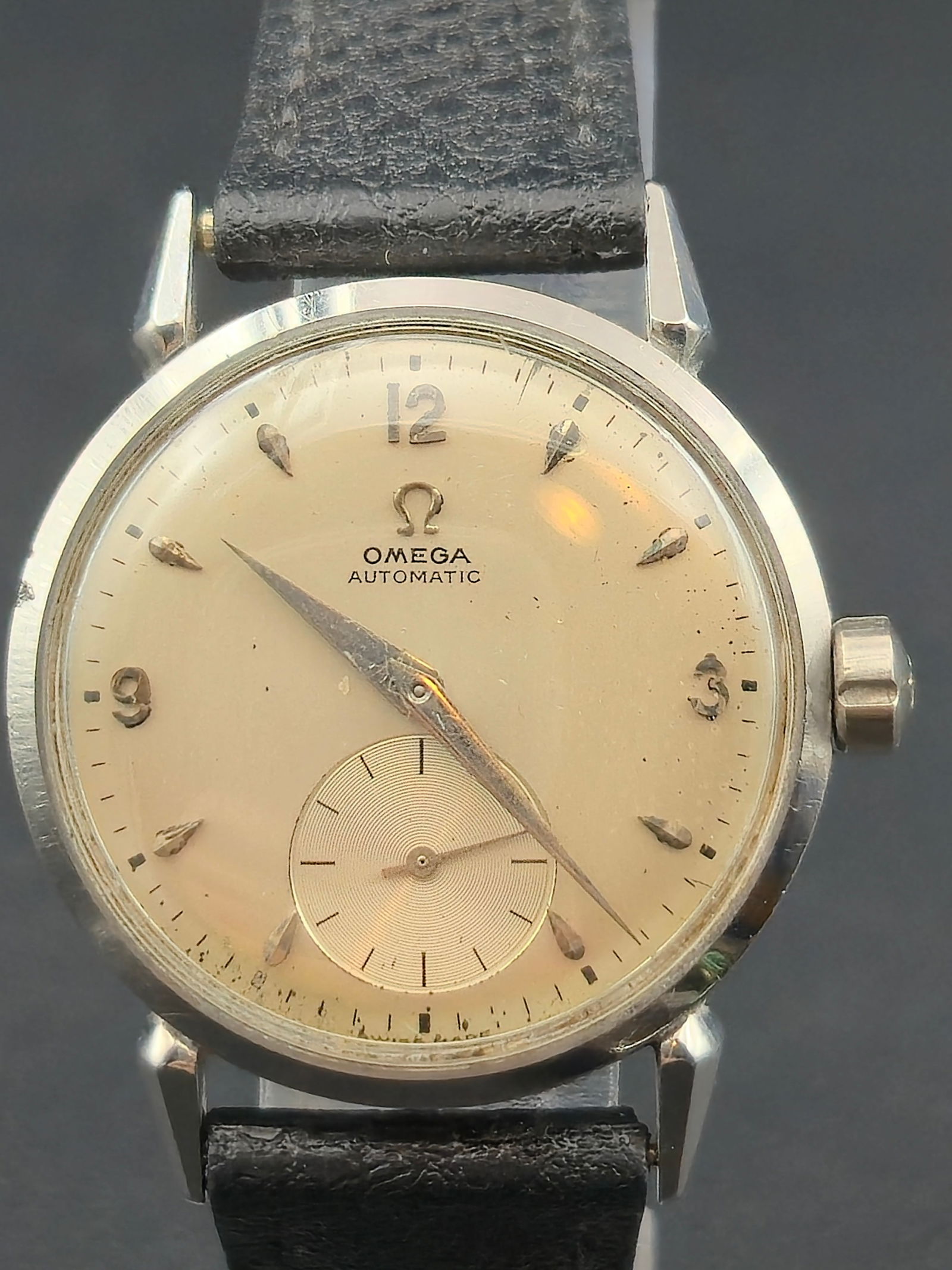 1950s Omega Bumper Automatic 32.39mm Stainless Steel Sub Seconds Dial Ref. 2321-1: This circa mid-1950s Omega bumper automatic wristwatch features a cream dial with applied Arabic numerals, dauphine-style hands, and a recessed sub-seconds register at 6 o’clock. The stainless steel