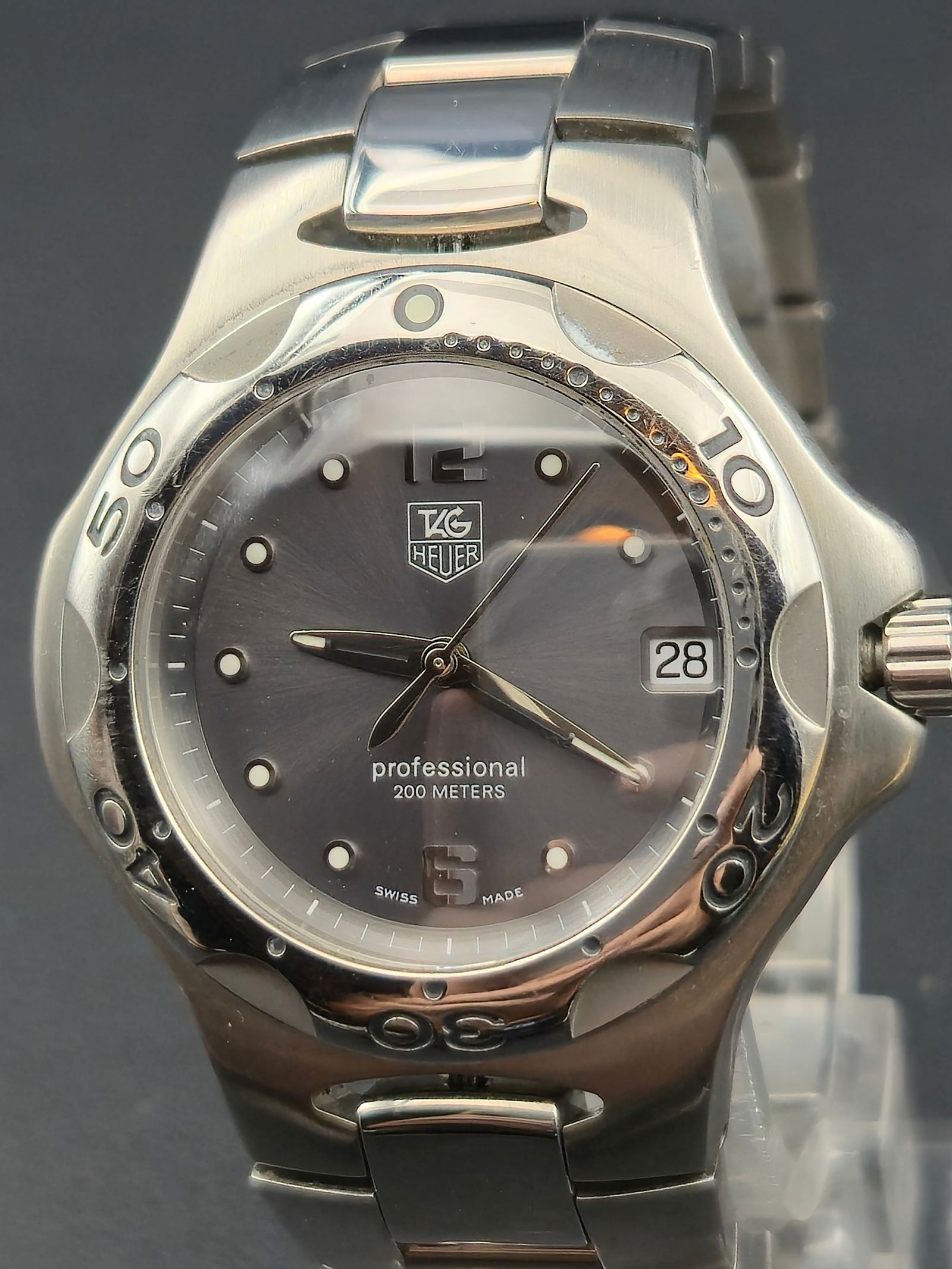 TAG Heuer Professional 200M WL111G Quartz 37.3mm Stainless Steel Date: TAG Heuer Professional wristwatch with stainless steel case and bracelet, reference WL111G. Black dial signed TAG Heuer Professional 200 Meters with luminous dot hour markers, applied Arabic numerals