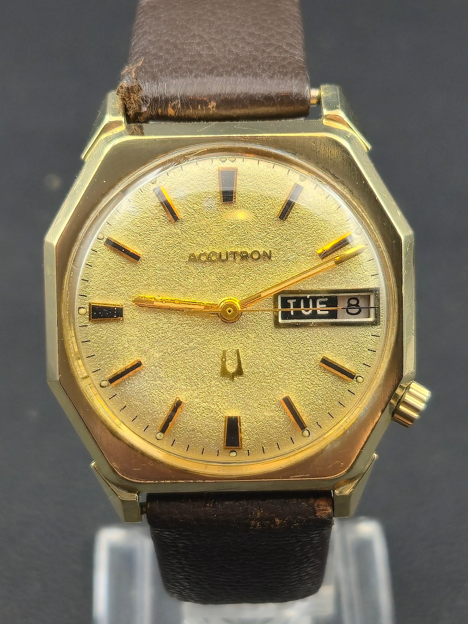 1972 Bulova Accutron 2182 14K Gold Filled Case Gold Dial Day Date 33.41mm: Bulova Accutron wristwatch with gold-tone dial. Dial reads ACCUTRON and features applied baton hour markers with tuning fork logo. Day-date window at 3 o’clock displaying TUE 8. Case is marked 14K G