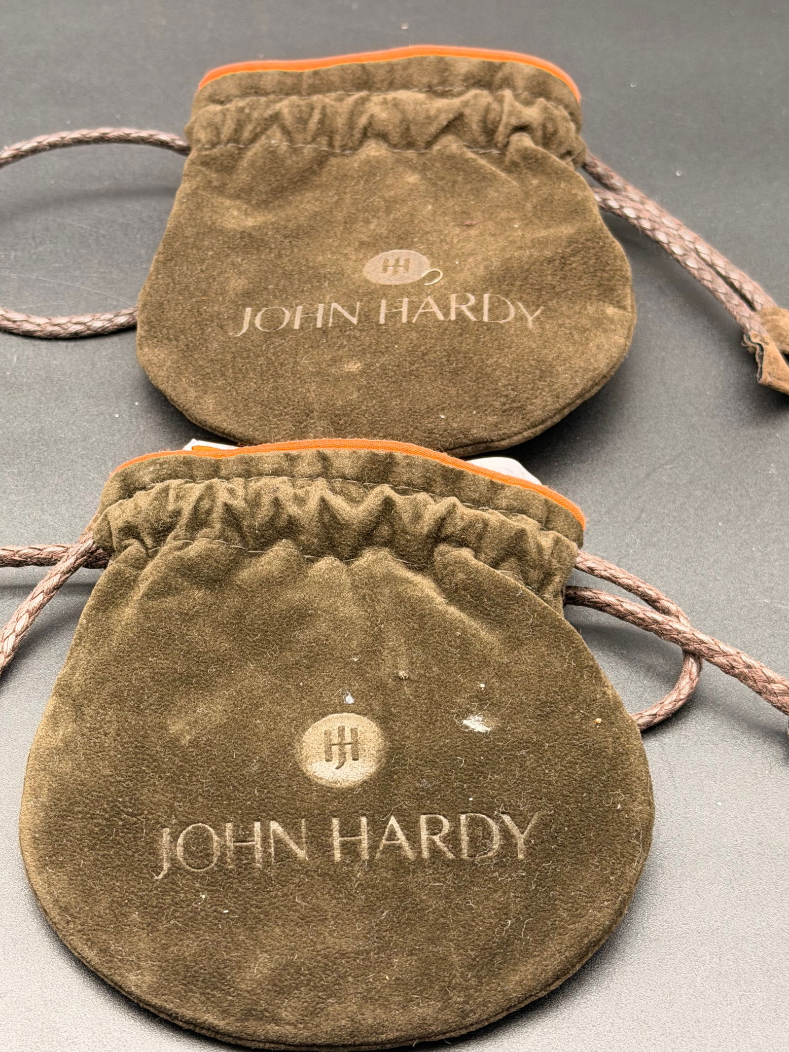John Hardy Jewelry Pouches Lot (2) + Original Polishing Cloth Authentic: Lot of authentic John Hardy jewelry accessories including two original suede drawstring pouches and two John Hardy branded polishing cloth.All pieces feature the John Hardy logo and are original brand