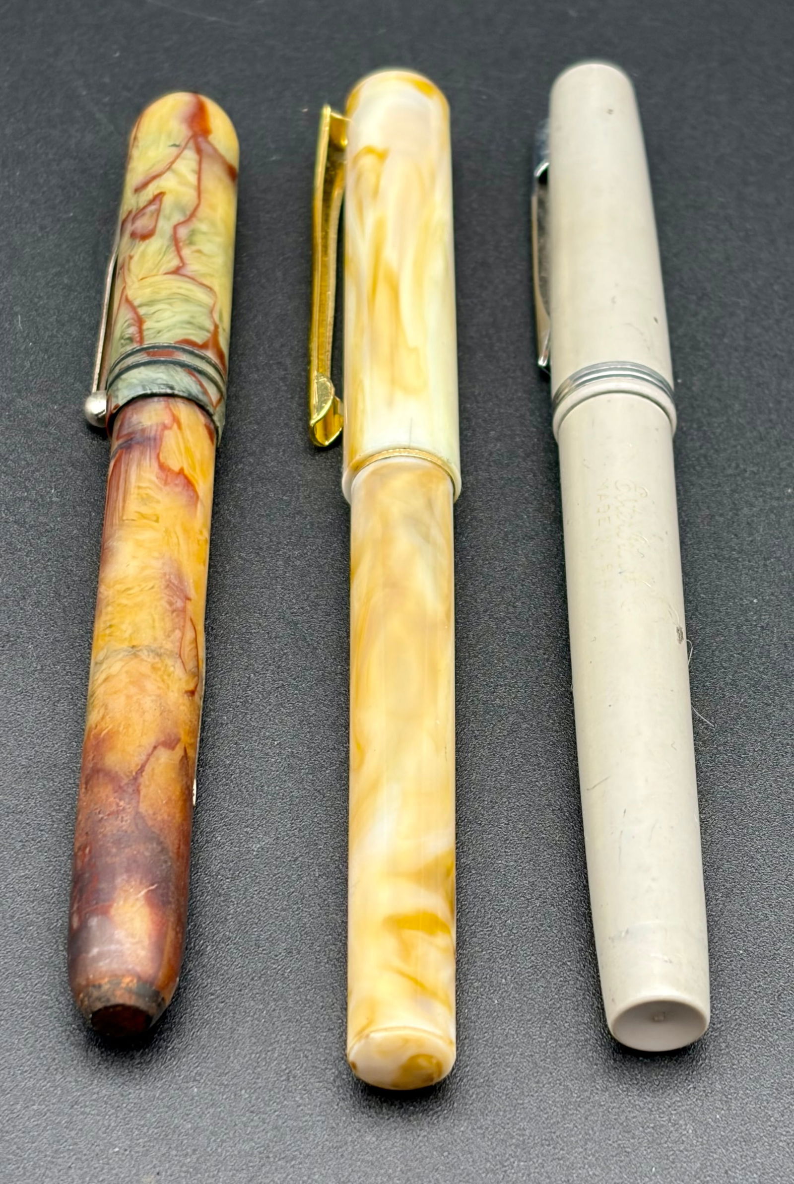 Vintage Fountain Pen Trio – Marbled Celluloid & Esterbrook Classic – Mid-Century Collectors Set: 1.Marbled Amber & Brown Celluloid Fountain PenA striking mid-century fountain pen with rich amber and chocolate marbling. Features a gold-tone nib and classic silhouette. Beautiful depth of color with