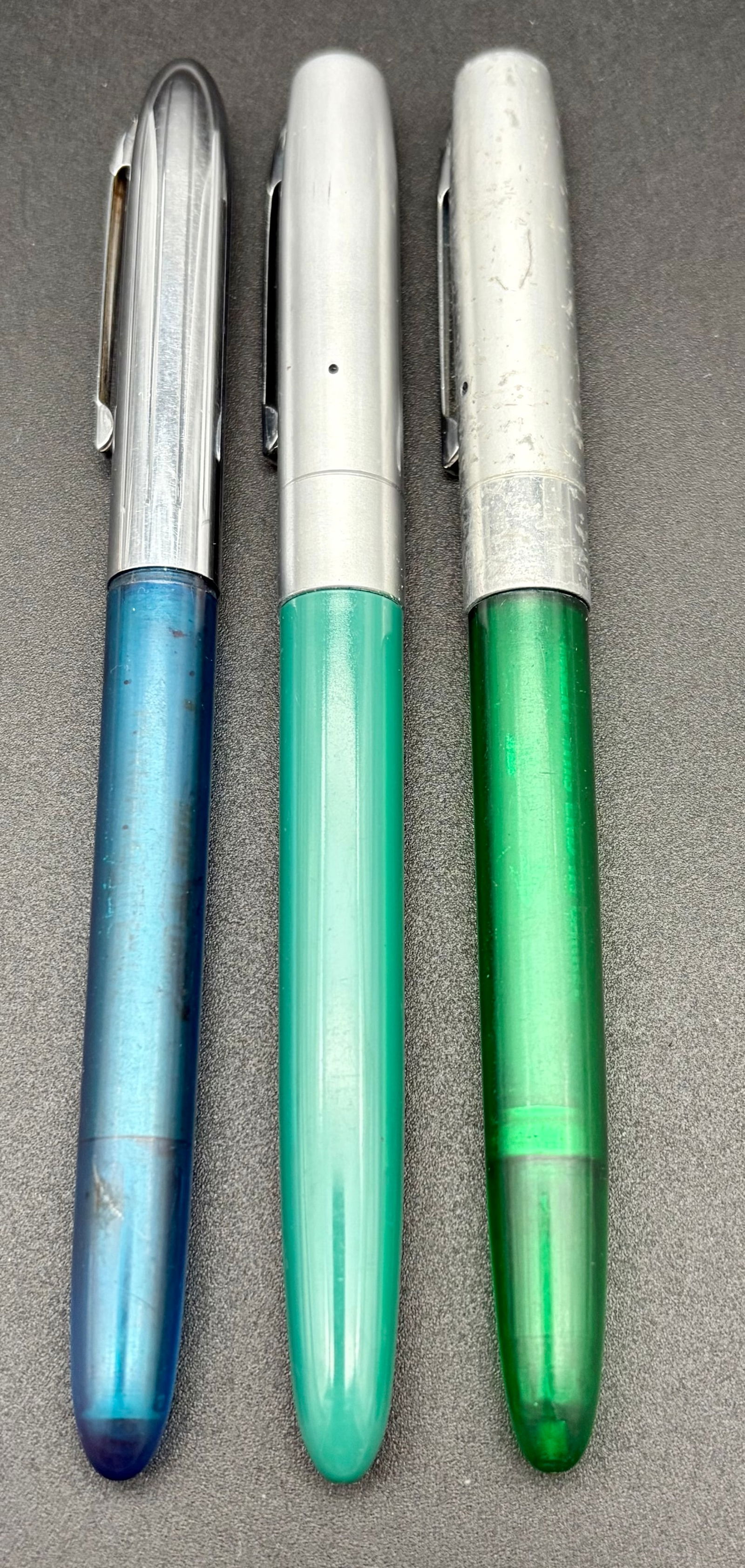 Vintage Fountain Pens – Blue, Aqua & Emerald Green – USA Made: A distinctive trio of authentic mid-century American fountain pens, featuring a mixed-maker set of two Wearever pens and one Sheaffer pen. Together, they represent the accessible elegance and craftsma
