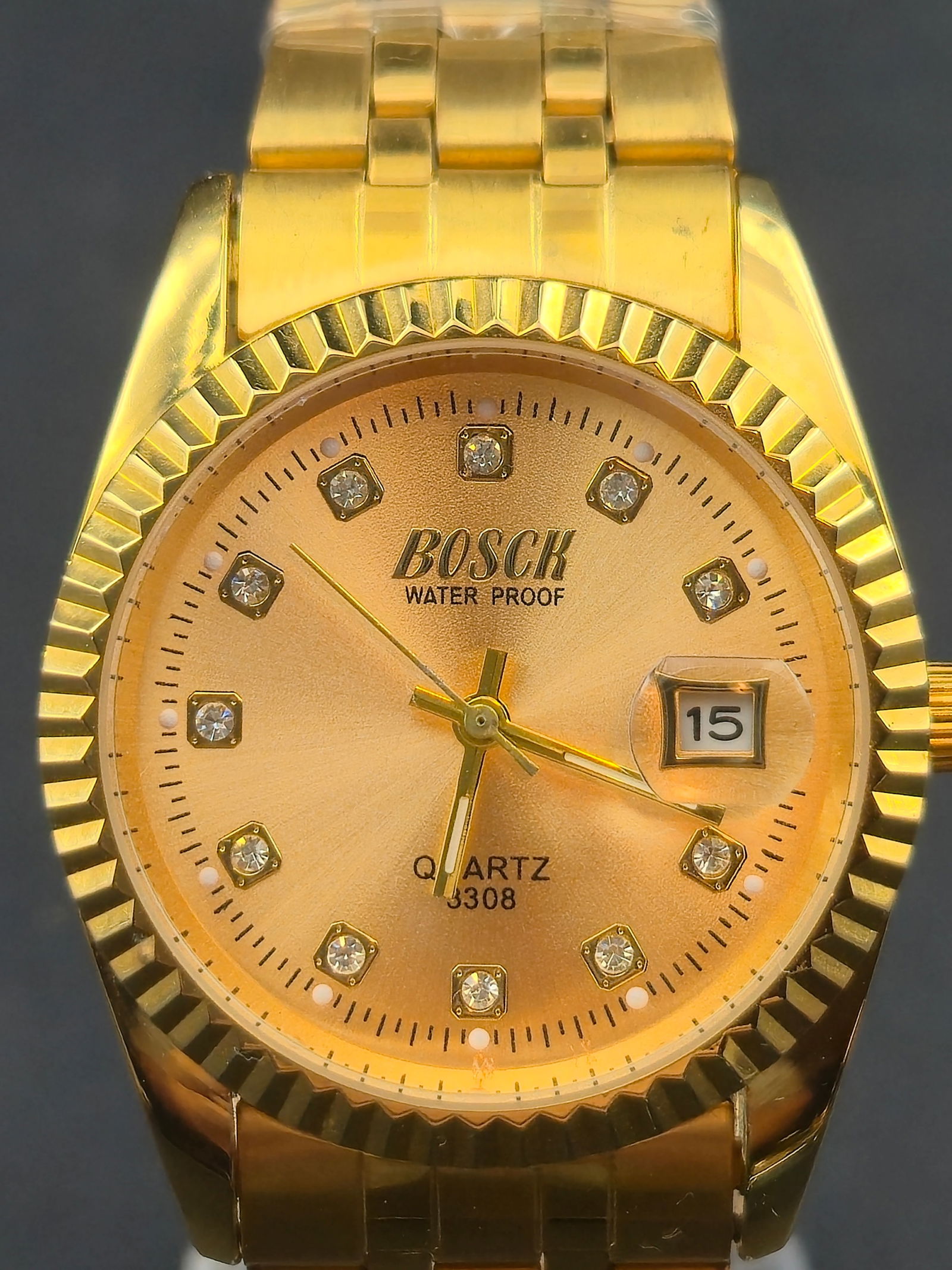 NOS Bosck Quartz Date 35mm Gold-Tone Crystal Dial Wristwatch – New Battery, Runs: New old stock (NOS) Bosck quartz wristwatch, featuring a gold-tone case and bracelet with a matching gold dial set with crystal hour markers. The watch is powered by a quartz movement marked 3308 and