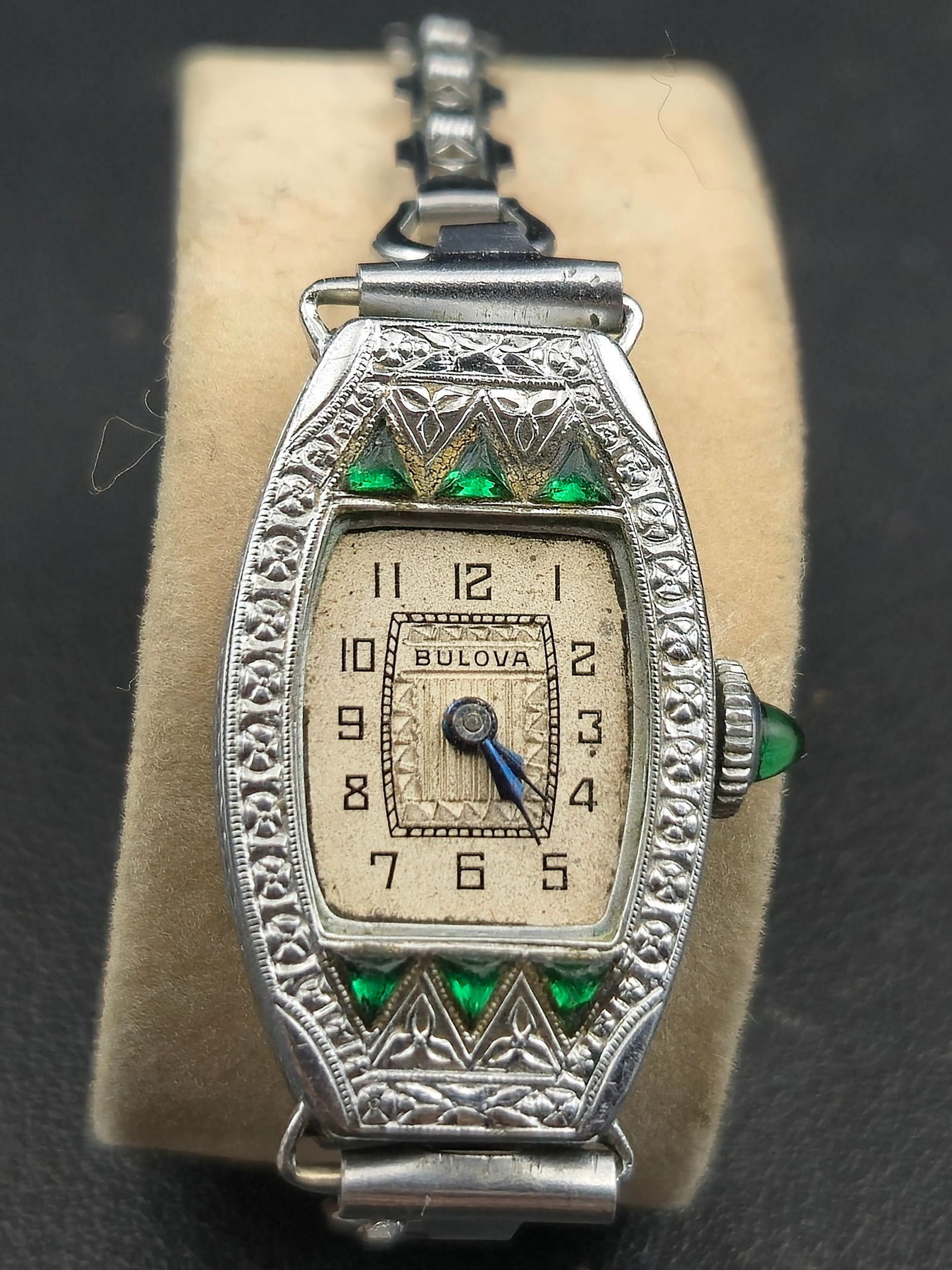 Bulova Art Deco Ladies Mechanical Wristwatch – Silver-Tone – c.1920s–1930s: Vintage Bulova ladies wristwatch in classic Art Deco style, featuring a silver-tone engraved case with green glass accent inlays and a rectangular cream dial with Arabic numerals. Dial is signed Bulov