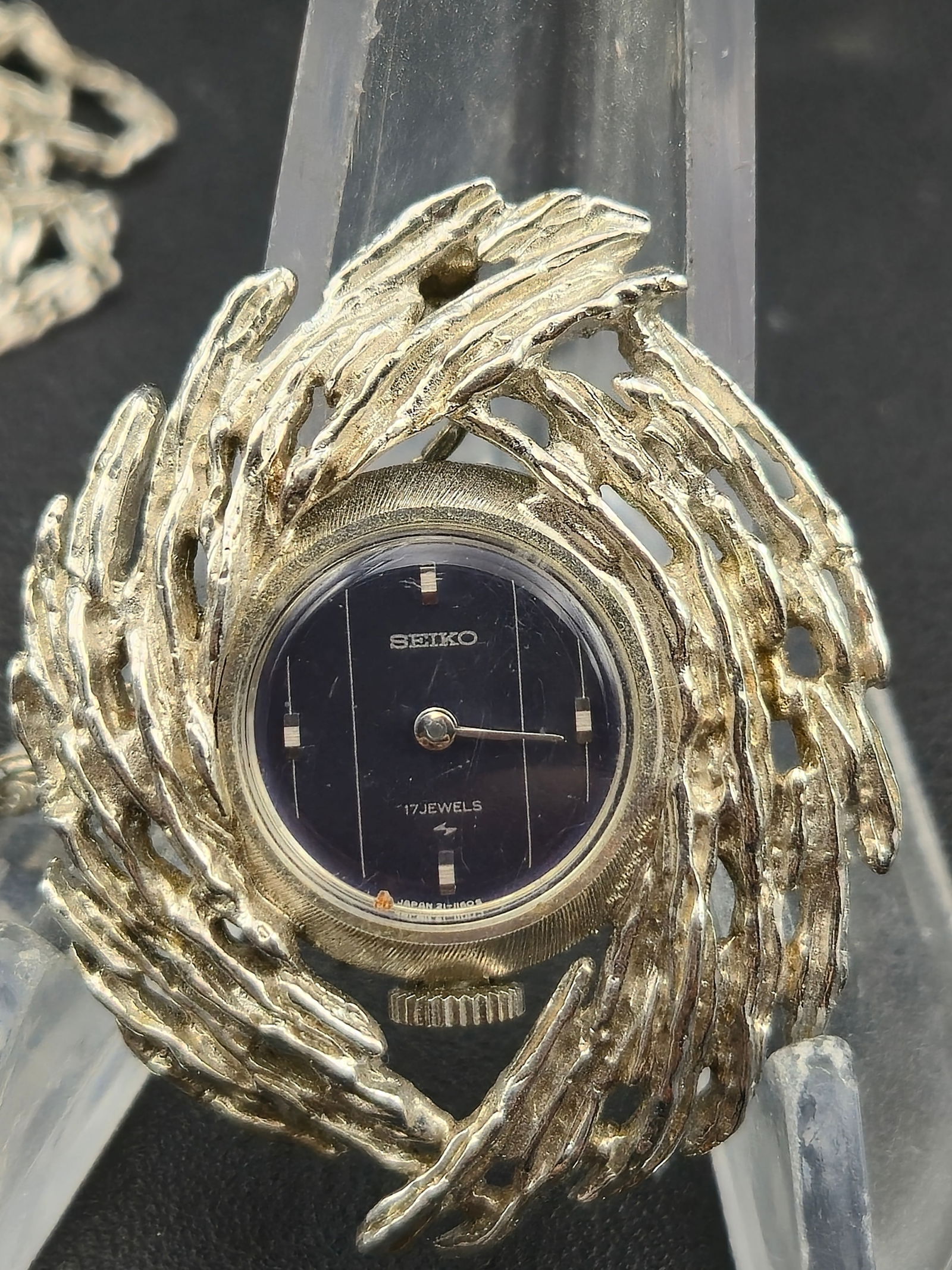 Circa 1970s Seiko 17J Pendant Necklace Watch WGP Case 35mm Running: Vintage Seiko pendant watch mounted in a sculptural openwork necklace-style surround. Features a dark blue dial with minimalist baton markers and silver-tone hands. Powered by a Seiko 17-jewel manual-