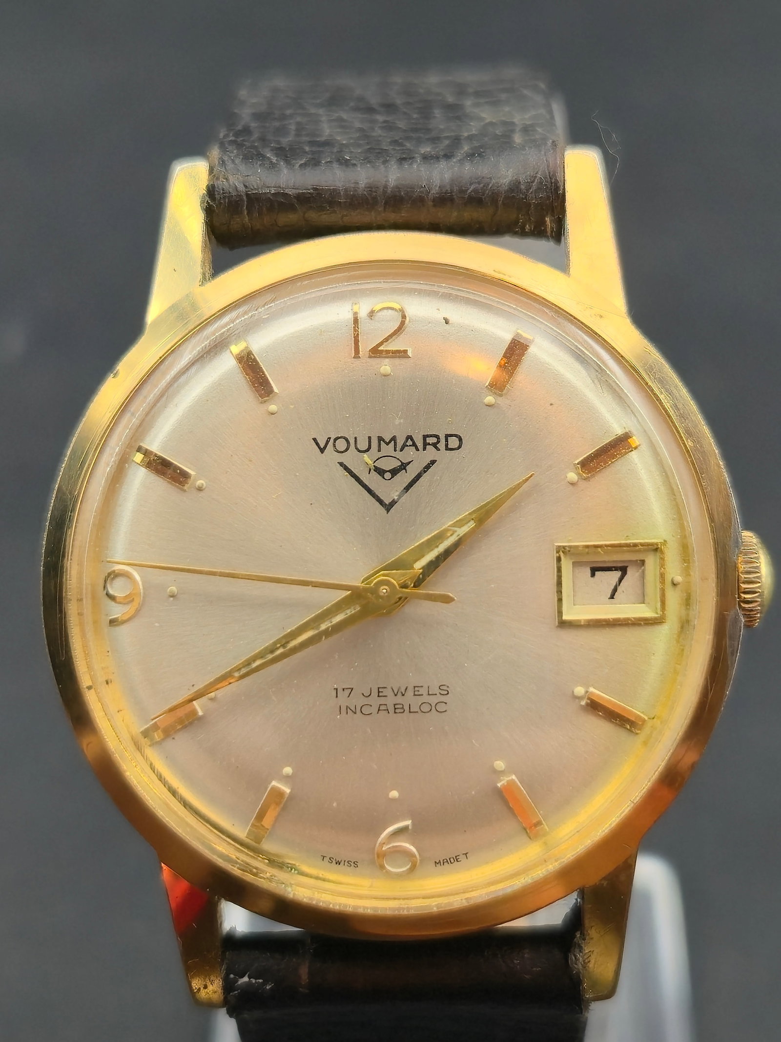 Voumard Neuchâtel Swiss 17J Incabloc Date Watch w/ Box & Papers: Vintage Voumard Neuchâtel Swiss wristwatch featuring a gold-tone case, silver sunburst dial, and date window at 3 o’clock. Dial is signed Voumard with applied indices and Arabic numerals at 12, 6,