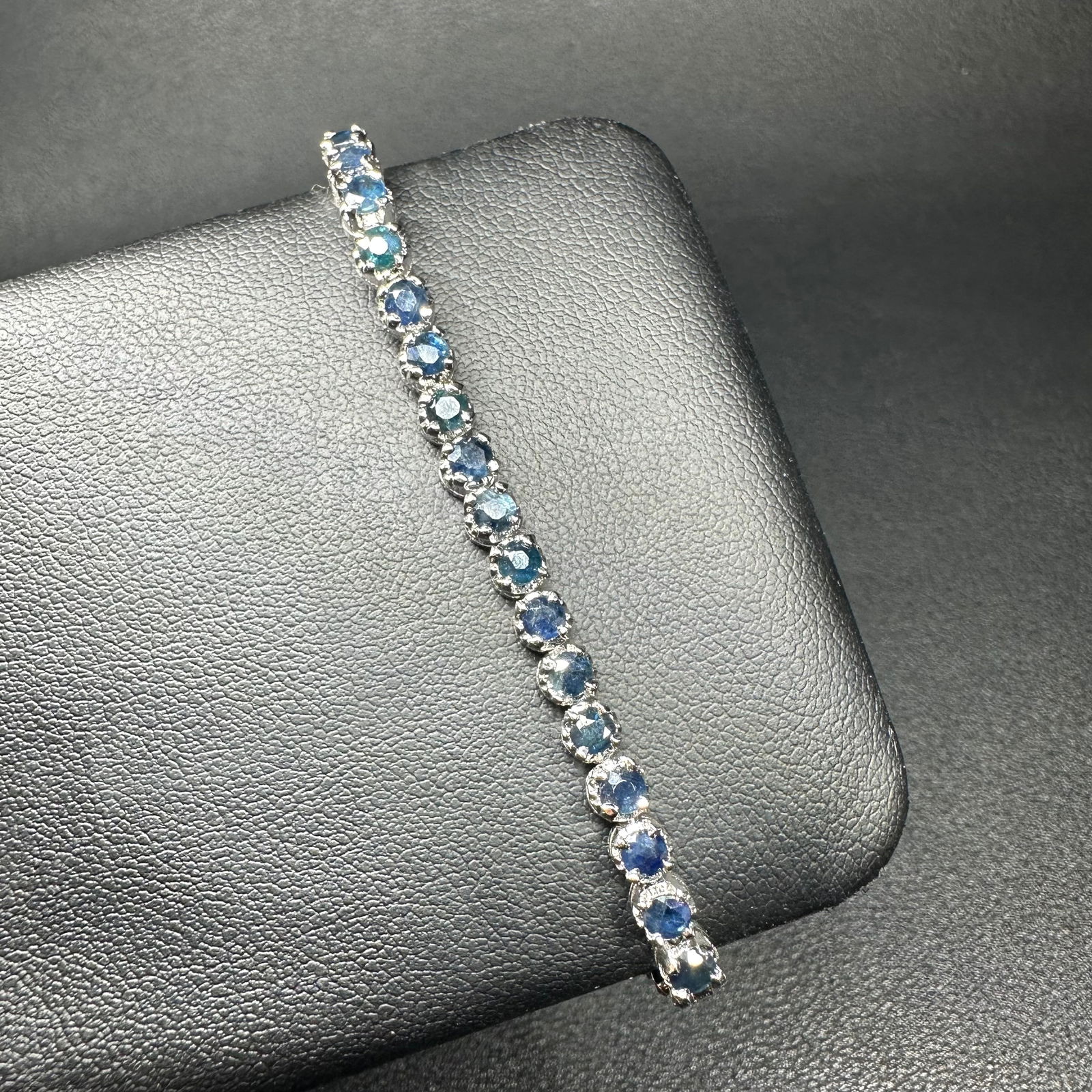 6.5"/7g Sterling Silver Faceted Blue Stone Tennis Bracelet: 6.5"/7g Sterling Silver Faceted Blue Stone Tennis Bracelet:Brand/Model: Unknown.Manufacturer Location: Not marked.Year Produced: Unknown; likely late 20th century.Condition: Overall good condition wit