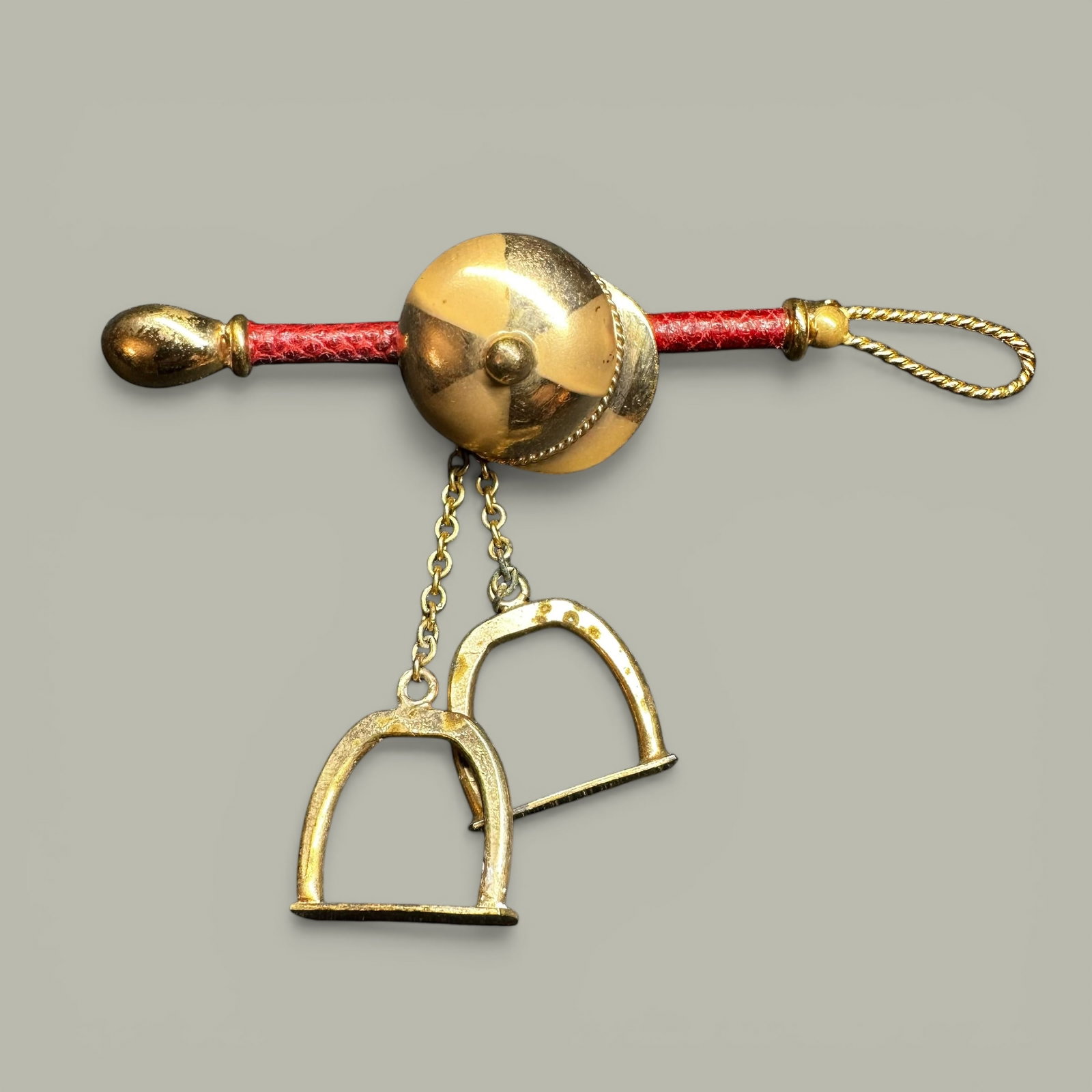 14g Vintage Gold Tone & Red Leather Jockey Themed Brooch: 14g Vintage Gold Tone & Red Leather Jockey Themed Brooch:Brand/Model: No hallmark.Manufacturer Location: Not marked.Year Produced: Unknown.Condition: Good vintage condition with surface wear, patina,