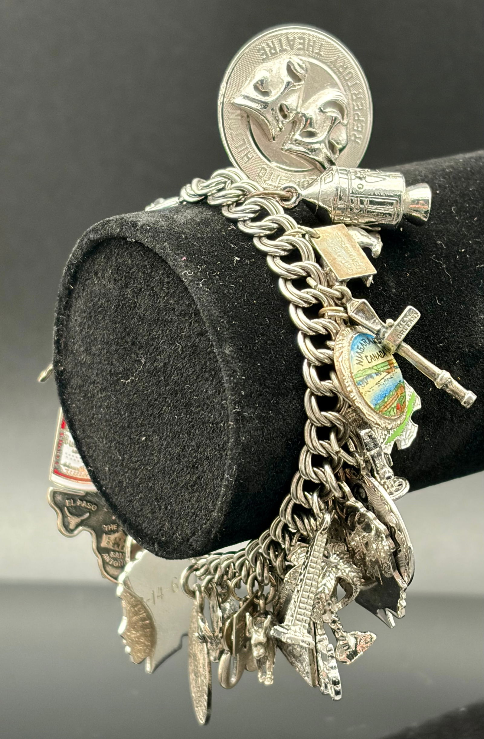 Vintage Sterling Silver Charm Bracelet – Travel & Landmark Charms: A beautiful vintage sterling silver charm bracelet featuring a rich collection of detailed travel and symbolic charms. The bracelet includes classic landmarks and motifs such as the Eiffel Tower, Cana