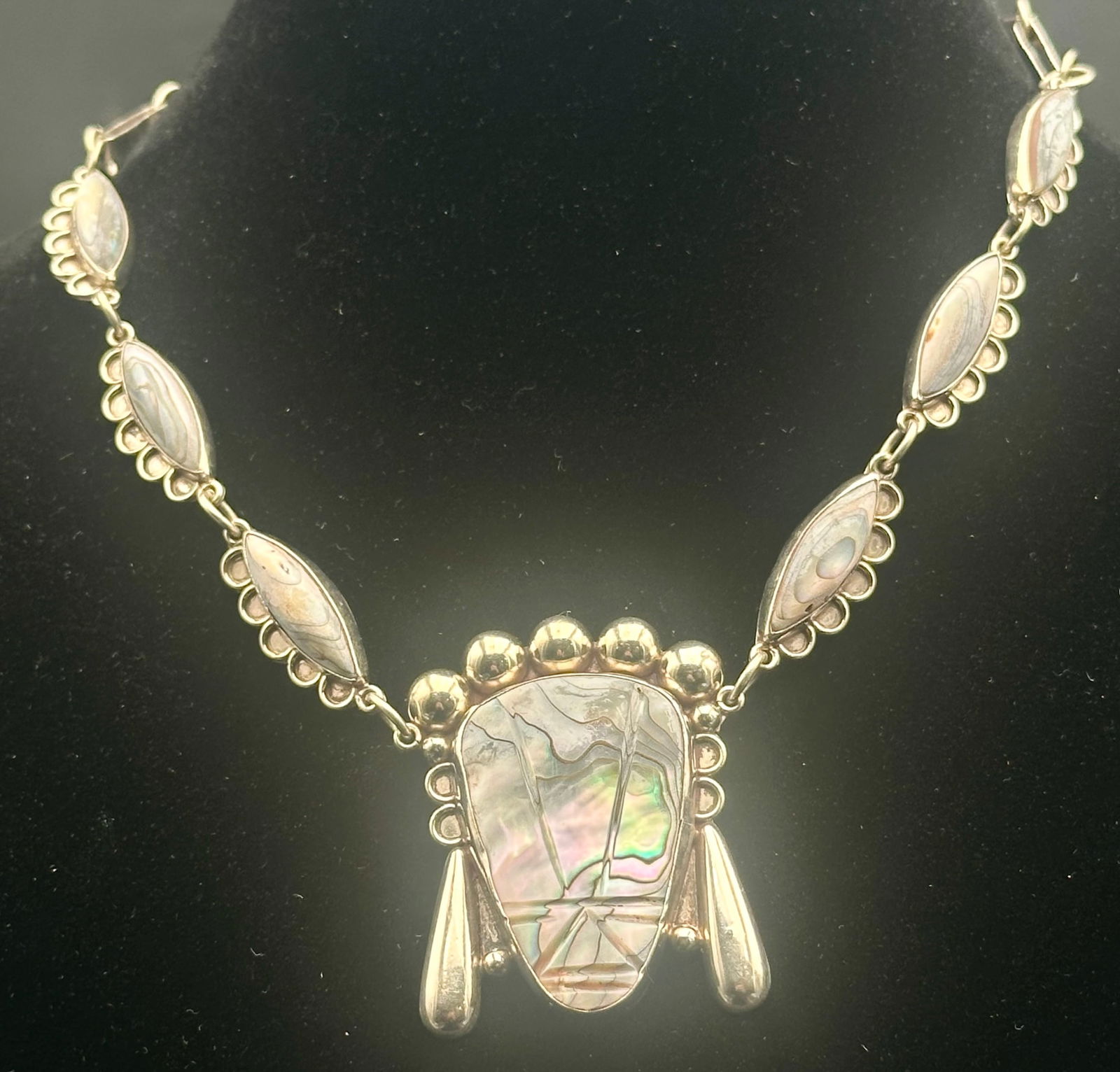 Vintage Mexican Sterling Silver Abalone Necklace – Eagle Mark – 42g: Vintage Mexican sterling silver necklace featuring a large natural abalone shell pendant with linked marquise abalone stations and decorative silver dangles. Marked 925 Mexico with eagle assay stamp.