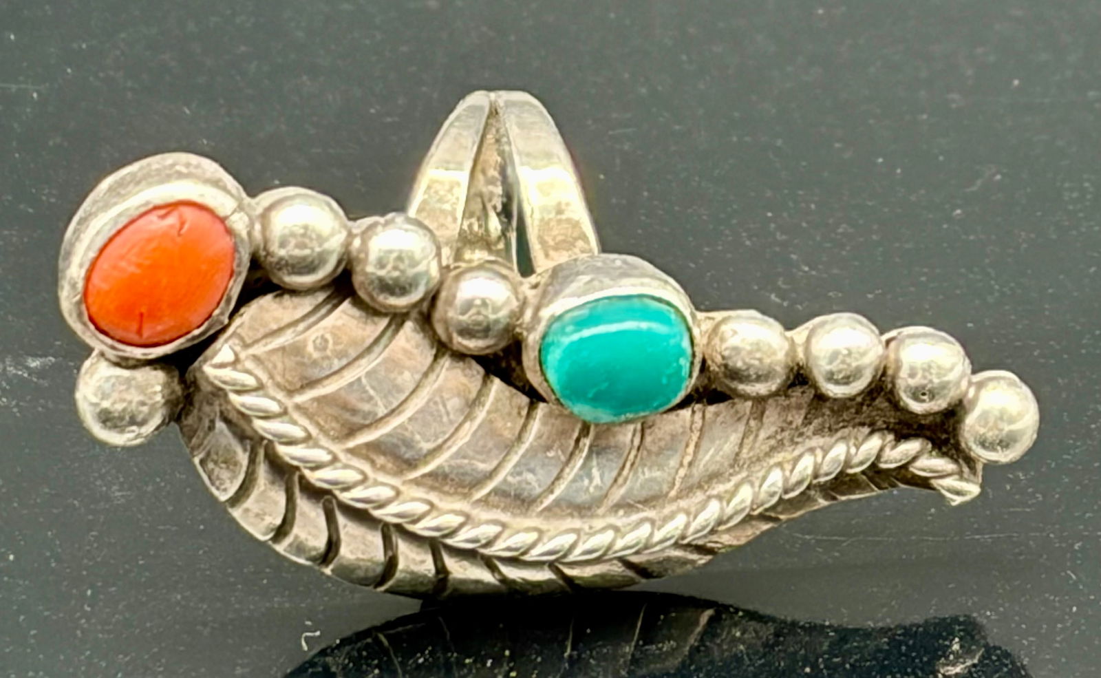 Vintage Southwestern Sterling Silver Feather Ring – Coral & Turquoise Accents: This elegant vintage ring features a beautifully sculpted sterling silver feather motif, accented with a vivid red coral cabochon and a soft green-blue turquoise stone. The feather is richly detailed