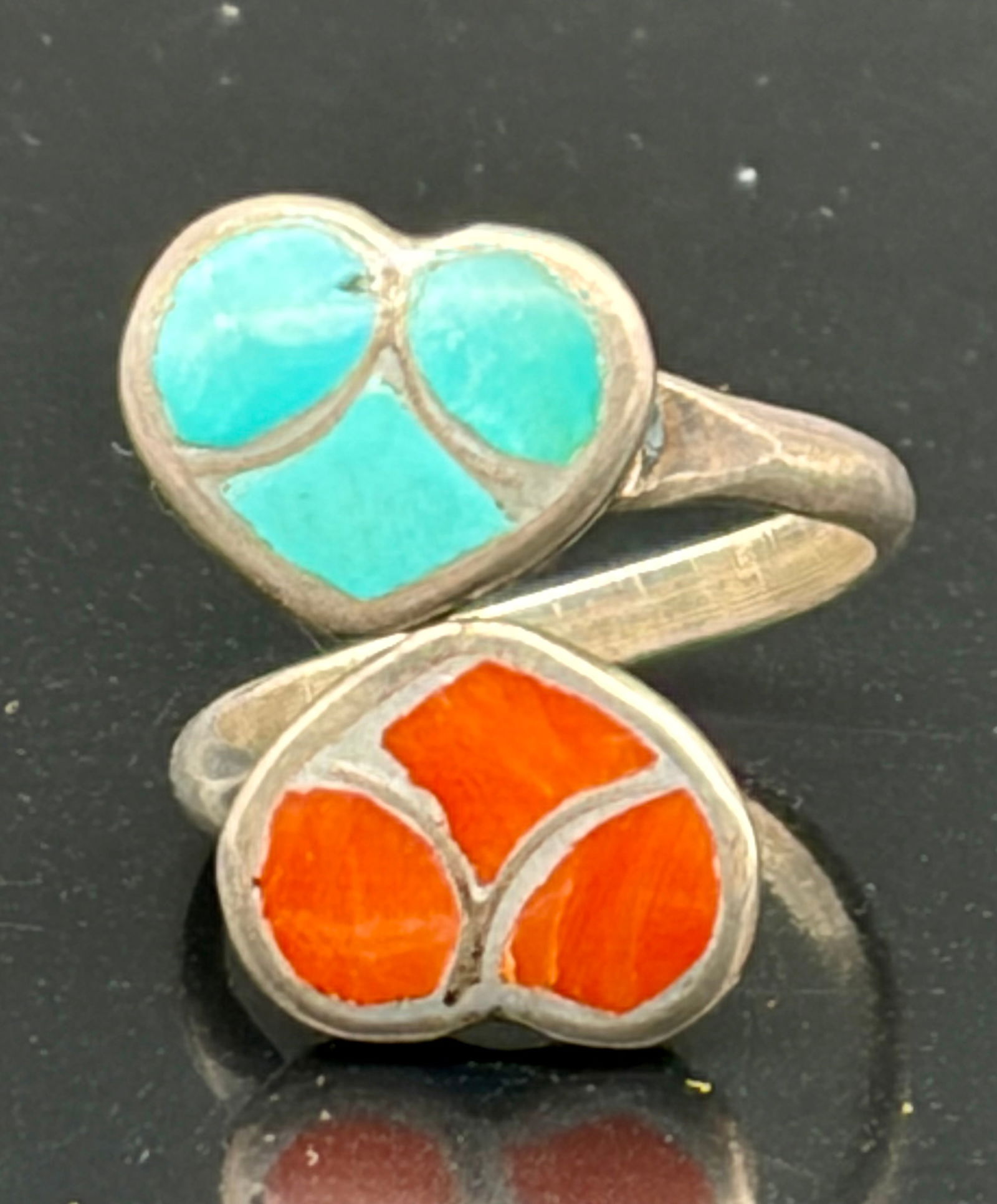Vintage Sterling Silver Turquoise & Coral Heart Inlay Ring: This charming vintage ring features a whimsical heart-shaped design with inlaid turquoise on one side and vivid coral on the other. The two hearts are joined in a graceful crossover style, creating a