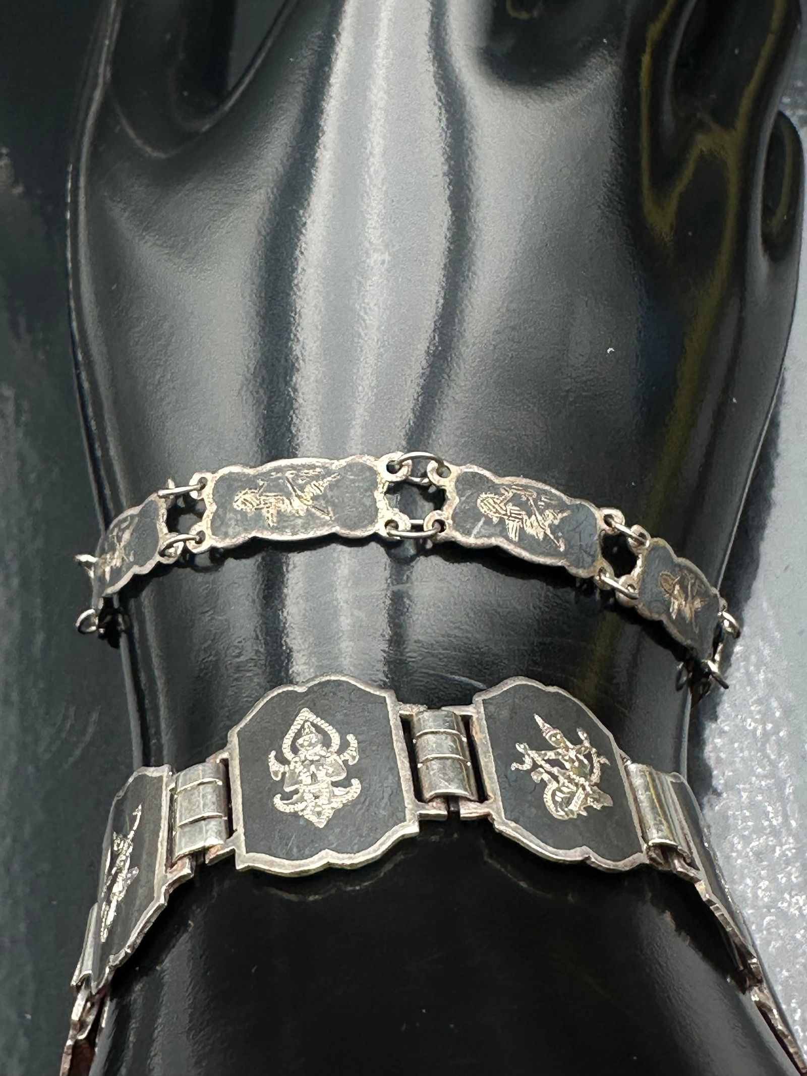 Lot of two beautiful Siam Niello Sterling Silver Bracelet – 26g: Vintage Siam sterling silver niello bracelets featuring traditional Thai mythological designs on blackened panels. Mid-20th century. Classic Siam export jewelry. Normal age wear. 26grams.