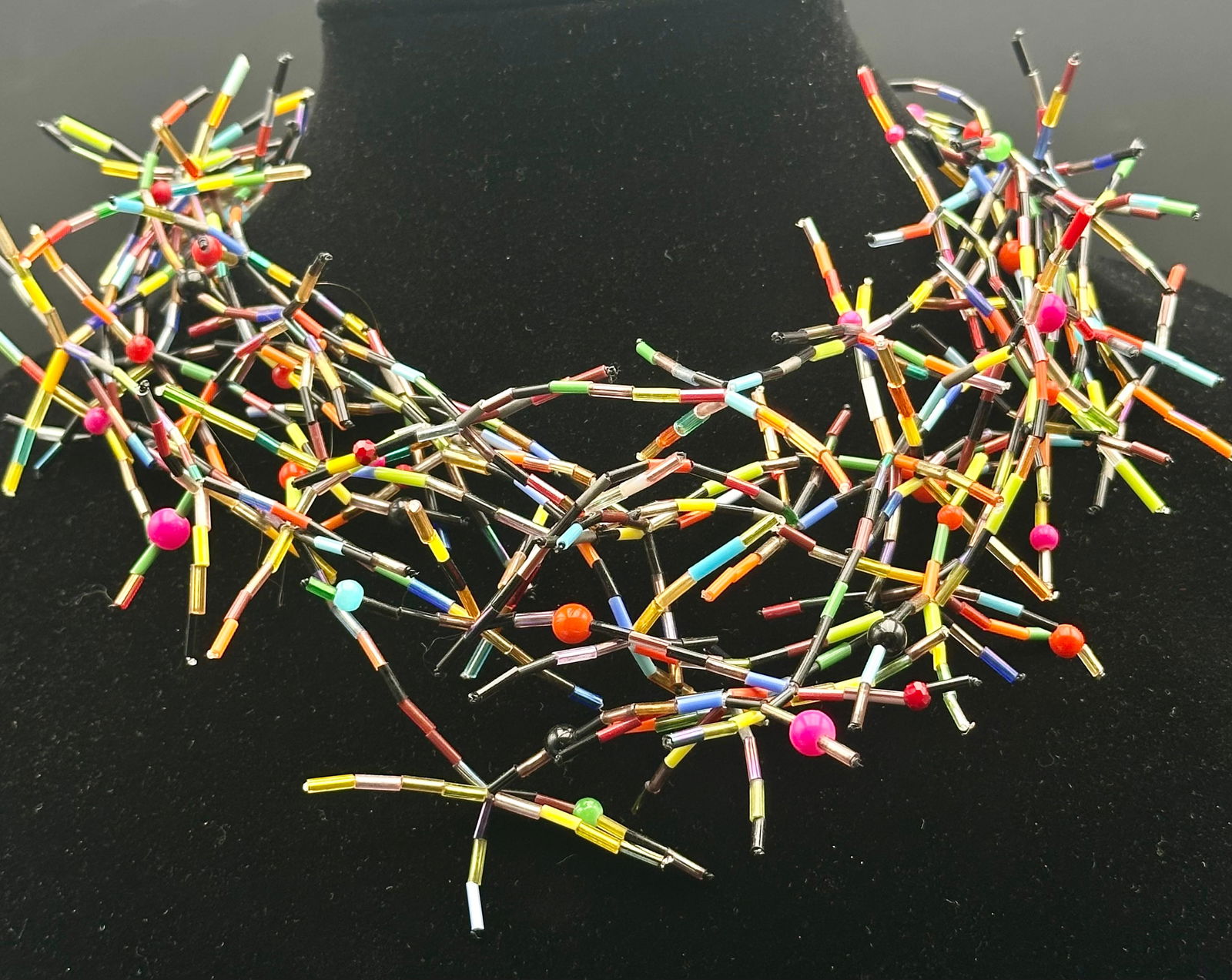 Vintage Multicolor Bugle Bead Statement Necklace: Vintage handcrafted statement necklace featuring multicolor glass bugle beads with scattered round accent beads. Bold, spiky sculptural design with a dramatic collar fit. Secures with a metal clasp an