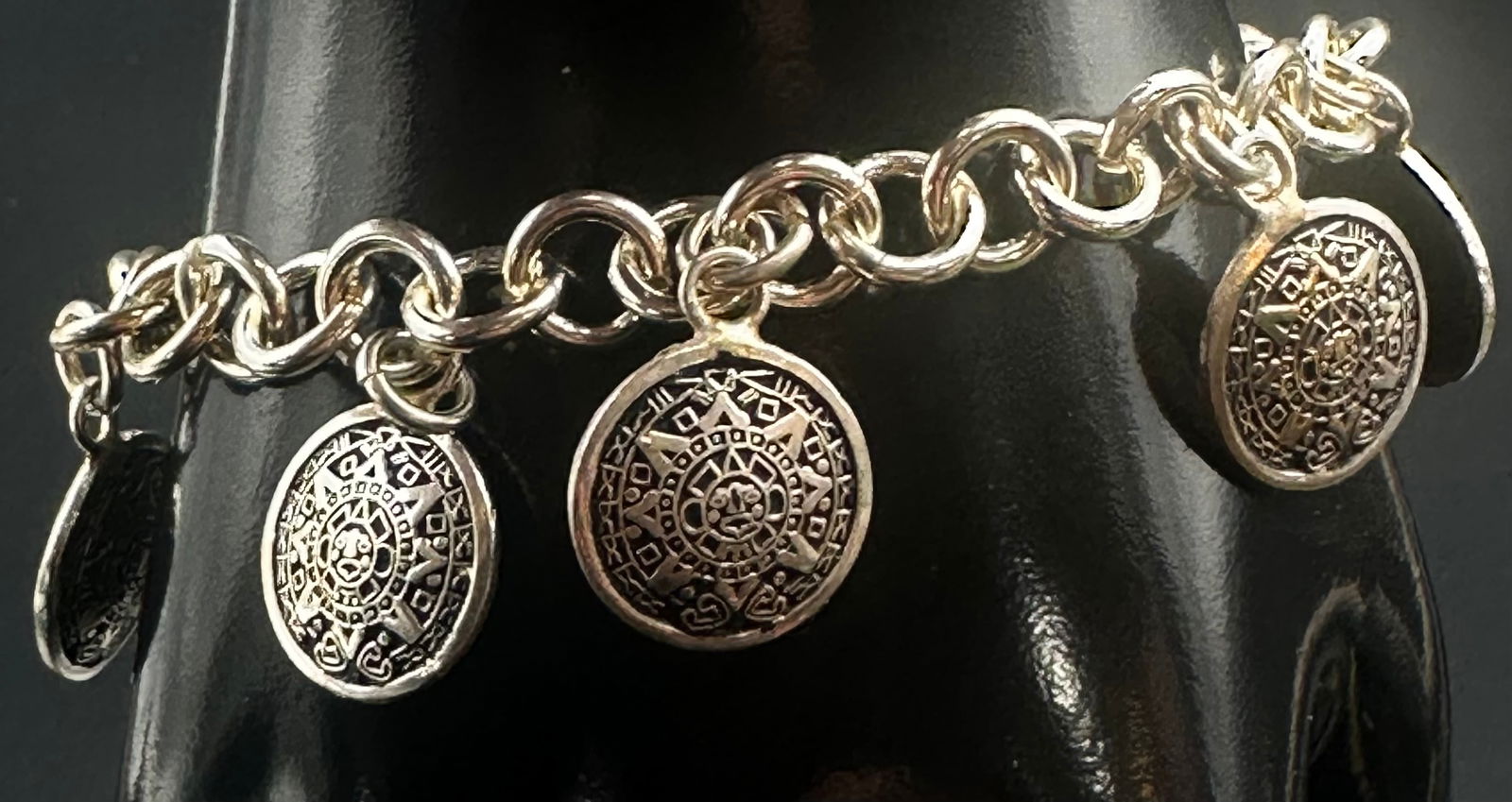 Vintage Sterling Silver Medallion Charm Bracelet w/ Toggle – 30g: Vintage sterling silver charm bracelet featuring a heavy round-link chain and multiple decorative medallion charms with geometric and stylized face motifs. The charms are ornamental talisman-style des