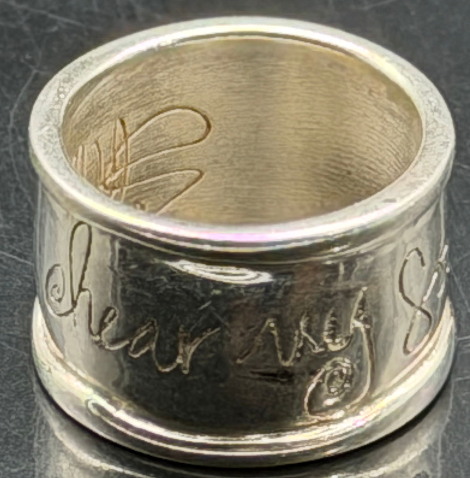 Wide Sterling Silver Script Band Ring – 20g: Heavy wide-band sterling silver ring with engraved/script lettering around the exterior and monogram-style engraving inside. Solid chunky construction with total weight 20 grams. Smooth comfort-fit in