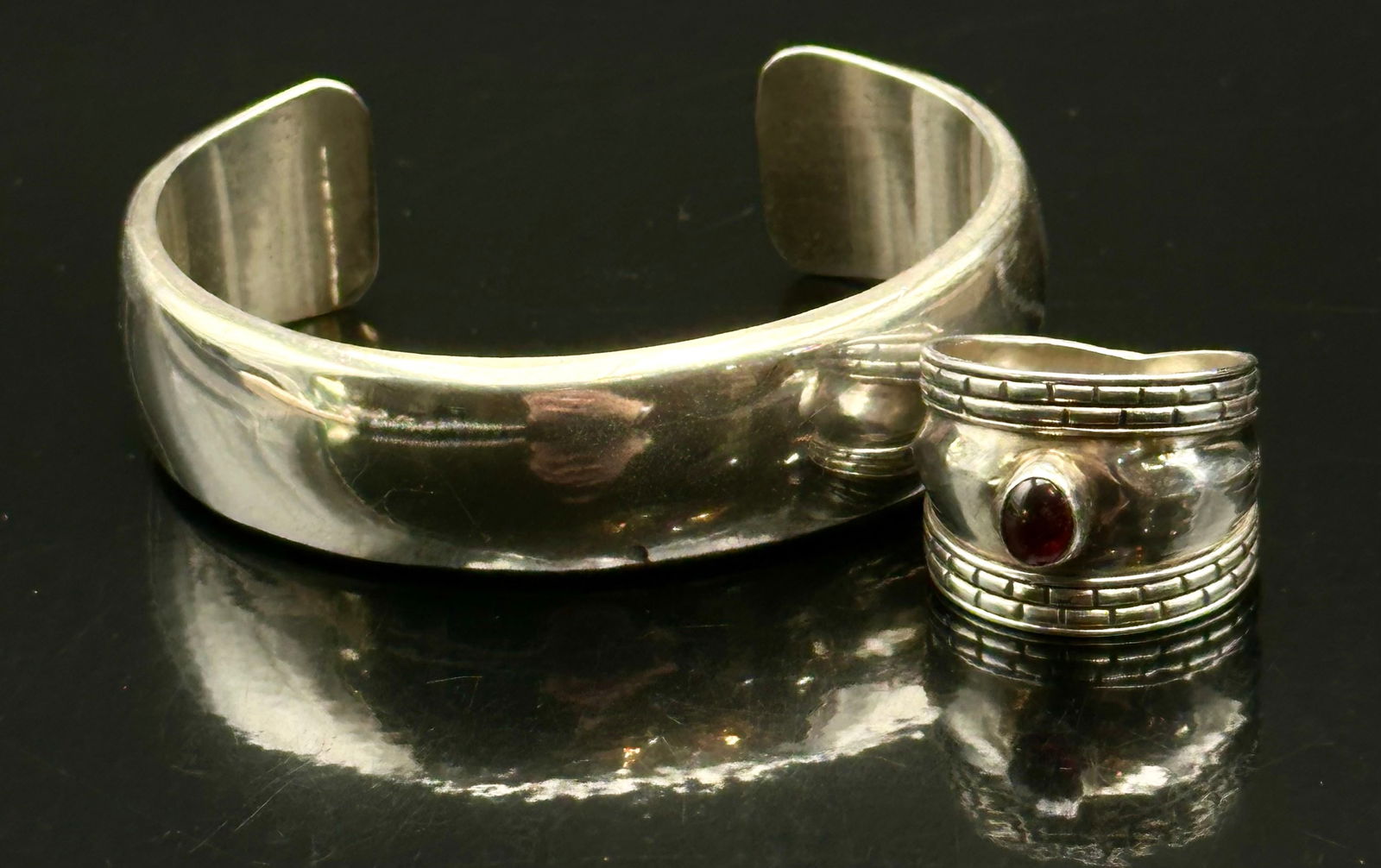 RM Sterling Wide Cuff Bracelet & Red Stone Band Ring Set – 27g: Vintage sterling silver jewelry set featuring a bold, wide RM marked sterling cuff bracelet paired with a heavy band ring set with an oval deep red cabochon stone. The cuff displays a sleek minimalist