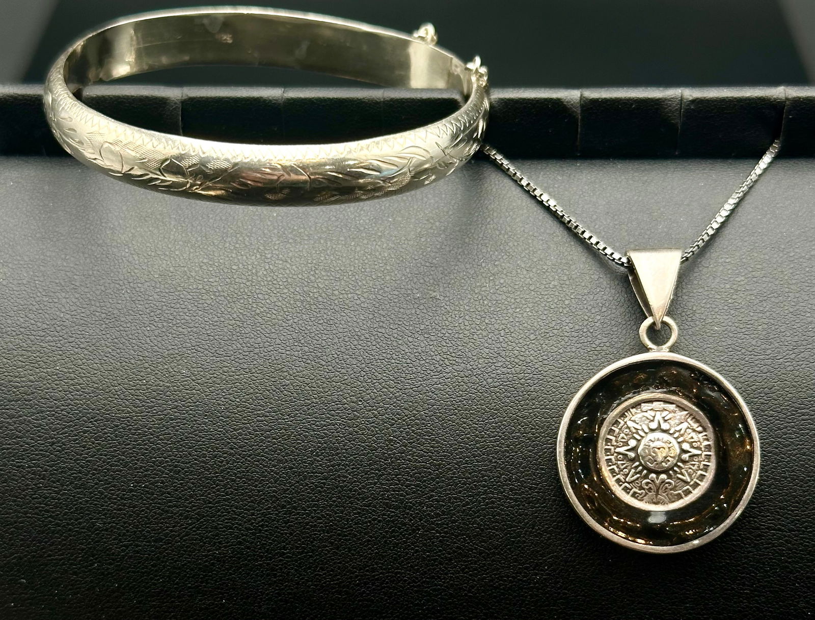 Sterling Silver Engraved Bangle Bracelet & Domed Medallion Pendant Necklace – 26g: Vintage sterling silver jewelry set featuring an engraved hinged bangle bracelet with decorative floral and scrollwork pattern paired with a statement pendant necklace displaying a raised medallion-st