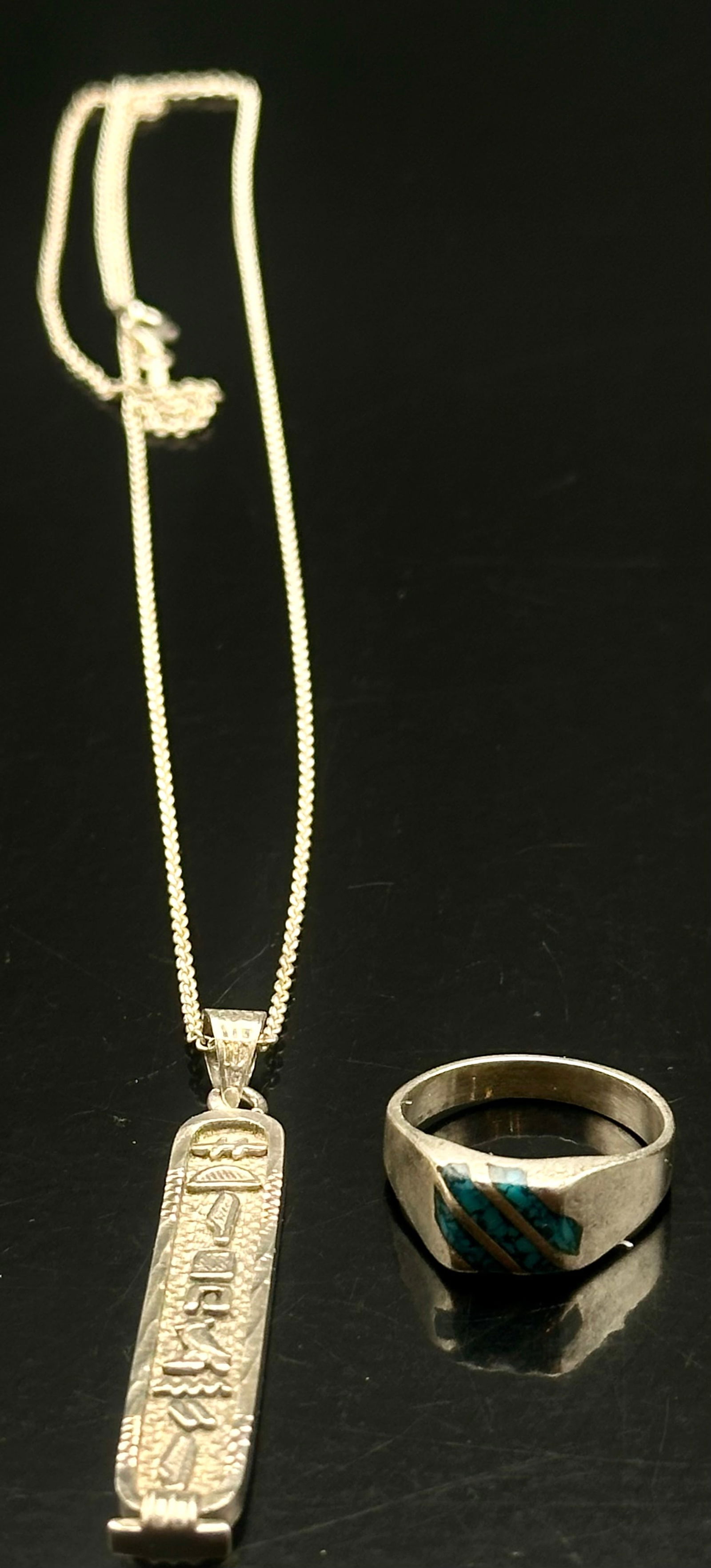 Sterling Silver Egyptian Hieroglyph Pendant Necklace & Turquoise Inlay Ring, 15g: Vintage sterling silver jewelry lot featuring an Egyptian revival style pendant necklace and a turquoise inlay band ring. The pendant displays raised hieroglyph motif detailing suspended from a sterli