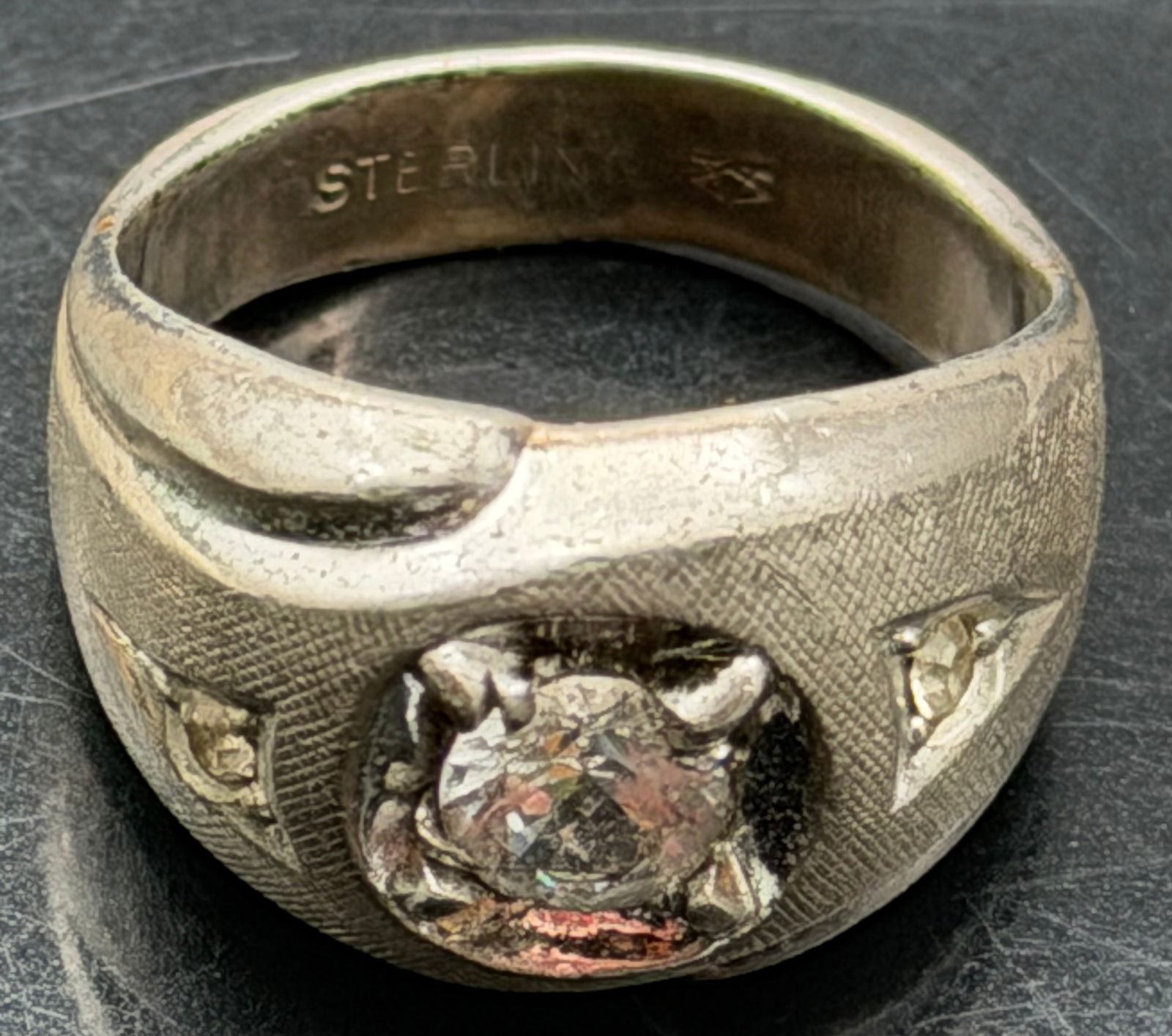 Vintage Sterling Silver Men’s Signet Ring Clear Stone Gypsy Set 11g: Vintage men’s ring crafted in solid sterling silver, marked STERLING inside the band. Features a gypsy-set round clear center stone with small accent stones on the shoulders and textured band design