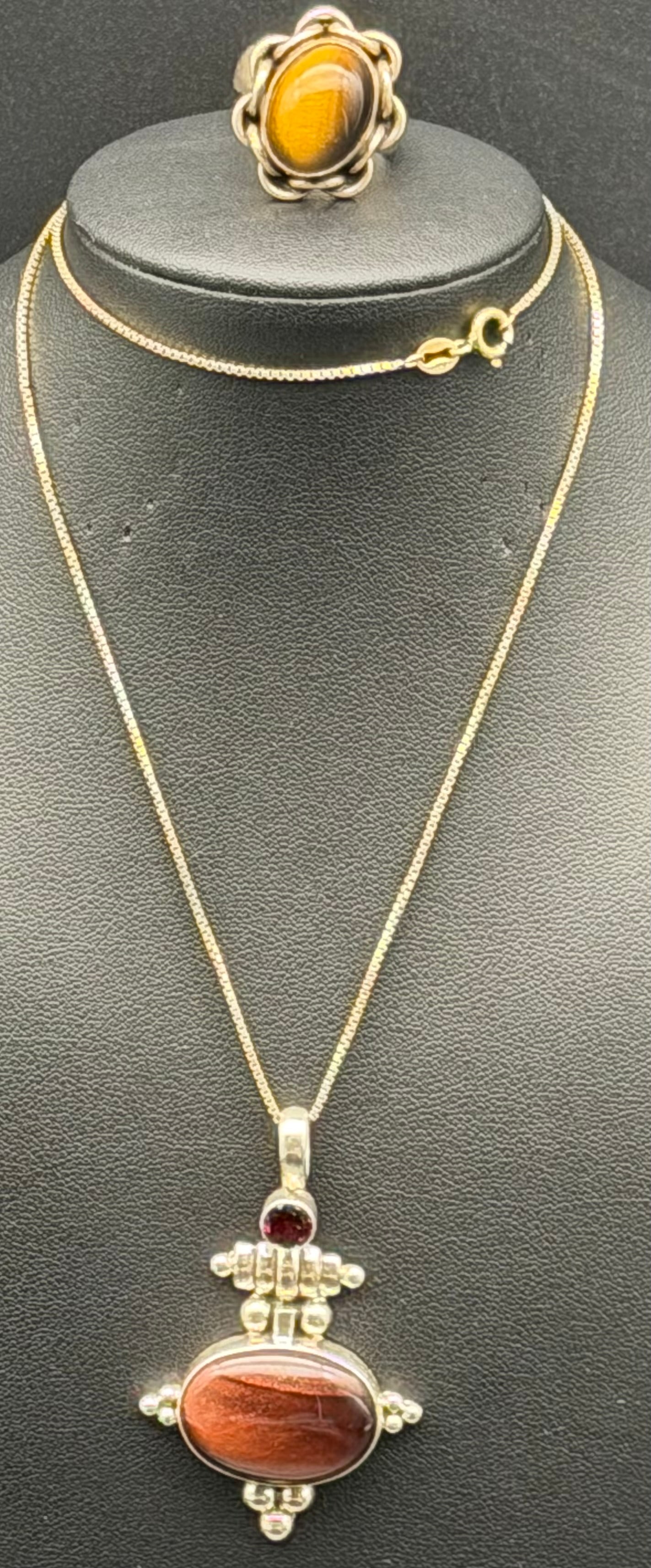 Sterling Silver 925 Tiger’s Eye Pendant Necklace & Ring Set 24g Garnet Accent: Beautiful sterling silver 925 jewelry set including pendant necklace and matching ring. Features a polished oval tiger’s eye stone with a decorative silver setting and a small red accent stone at th