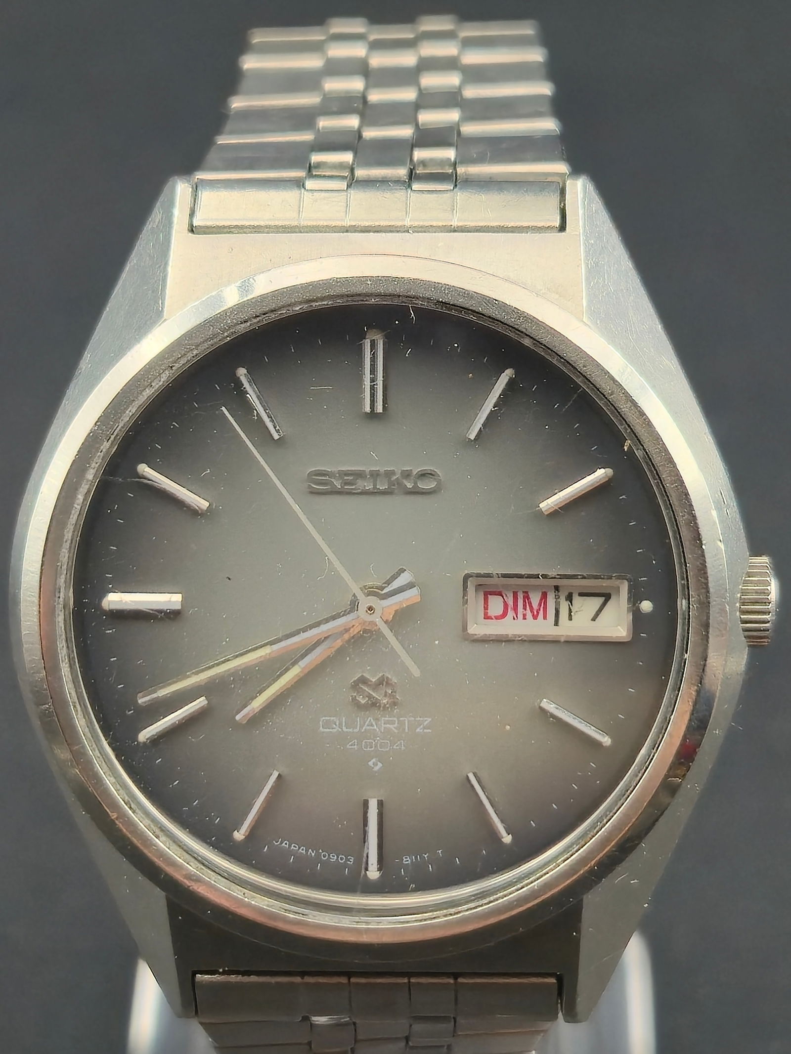 Seiko Quartz Day Date Stainless Steel Wristwatch Gray Dial 36mm circa 1980s: Seiko quartz wristwatch featuring a gray sunburst dial with applied silver-tone baton hour markers and matching hands. Day-date display at 3 o’clock with bilingual day wheel. Dial signed Seiko Quart