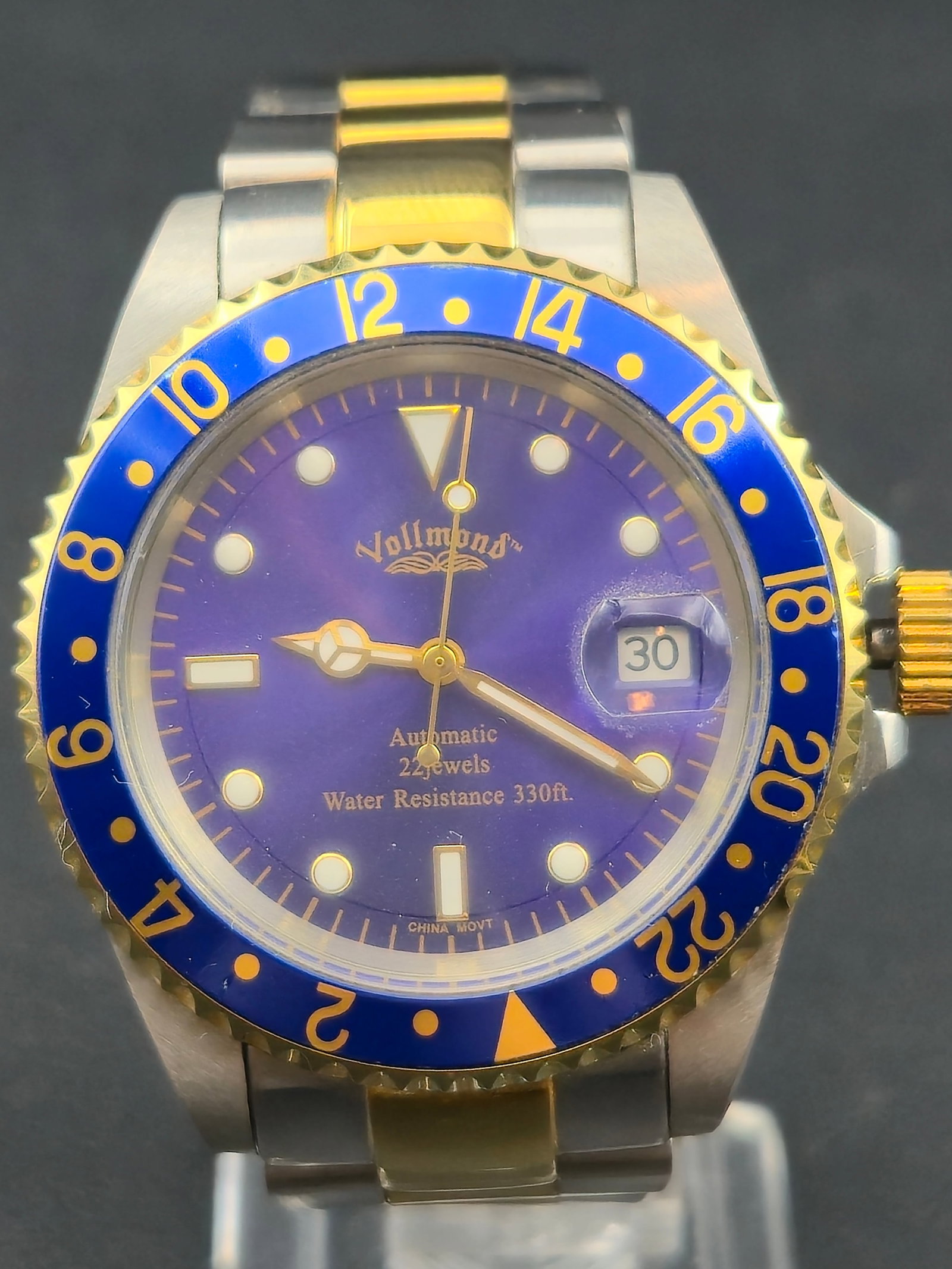1990s Vollmond Automatic Diver 22 Jewels Blue Dial Two Tone 40mm Running: Vollmond automatic diver-style wristwatch featuring a blue dial with luminous round markers, triangle marker at 12, and date window at 3. Dial is marked Automatic, 22 Jewels, and Water Resistance 330 
