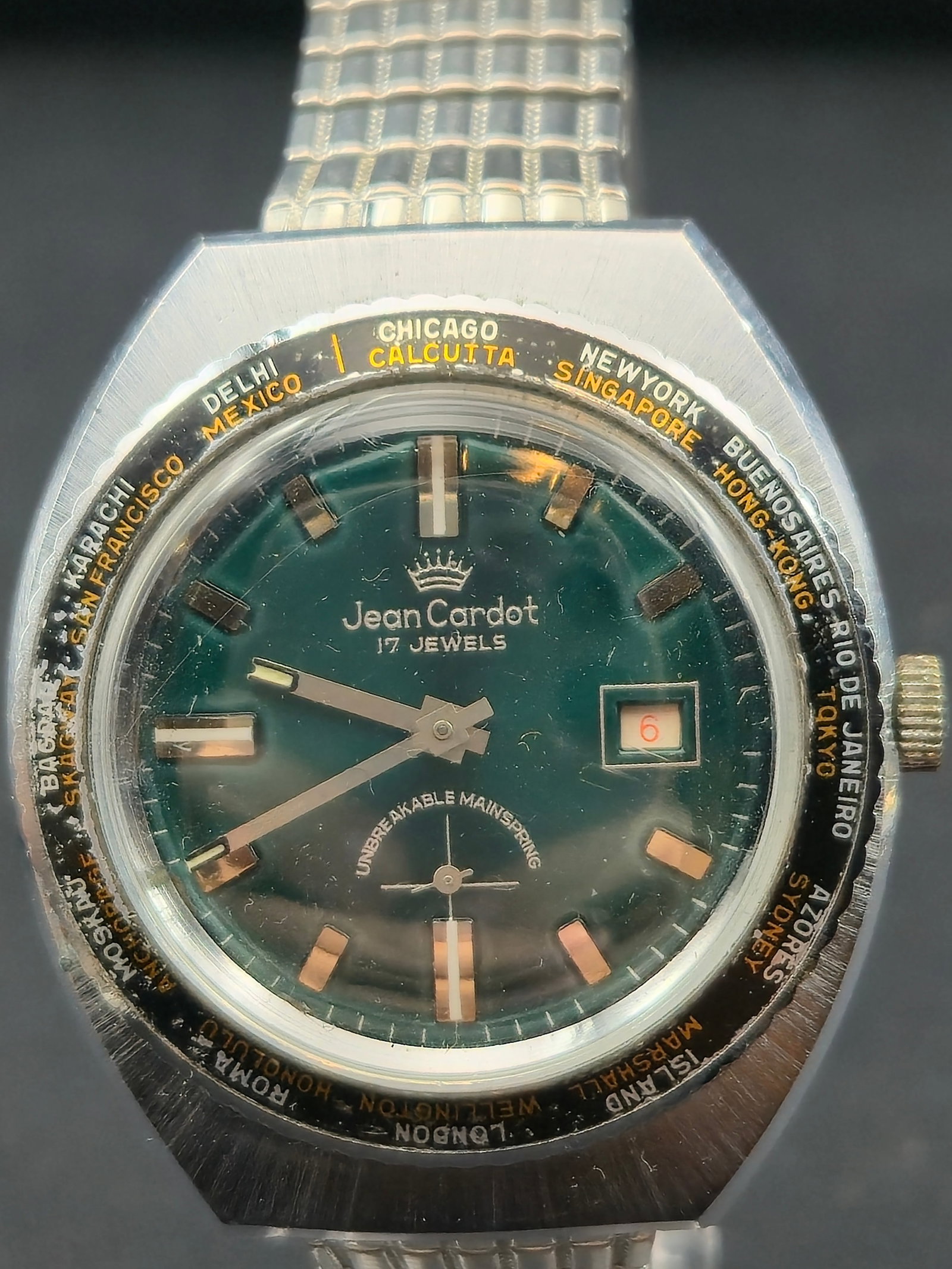 1970s Jean Cardot World Time 17J Automatic Green Dial Stainless Back Running: Vintage Jean Cardot automatic wristwatch featuring a green dial with world-time city ring. Dial is signed Jean Cardot, 17 Jewels, and Unbreakable Mainspring, with date window at 3. Caseback is stamped