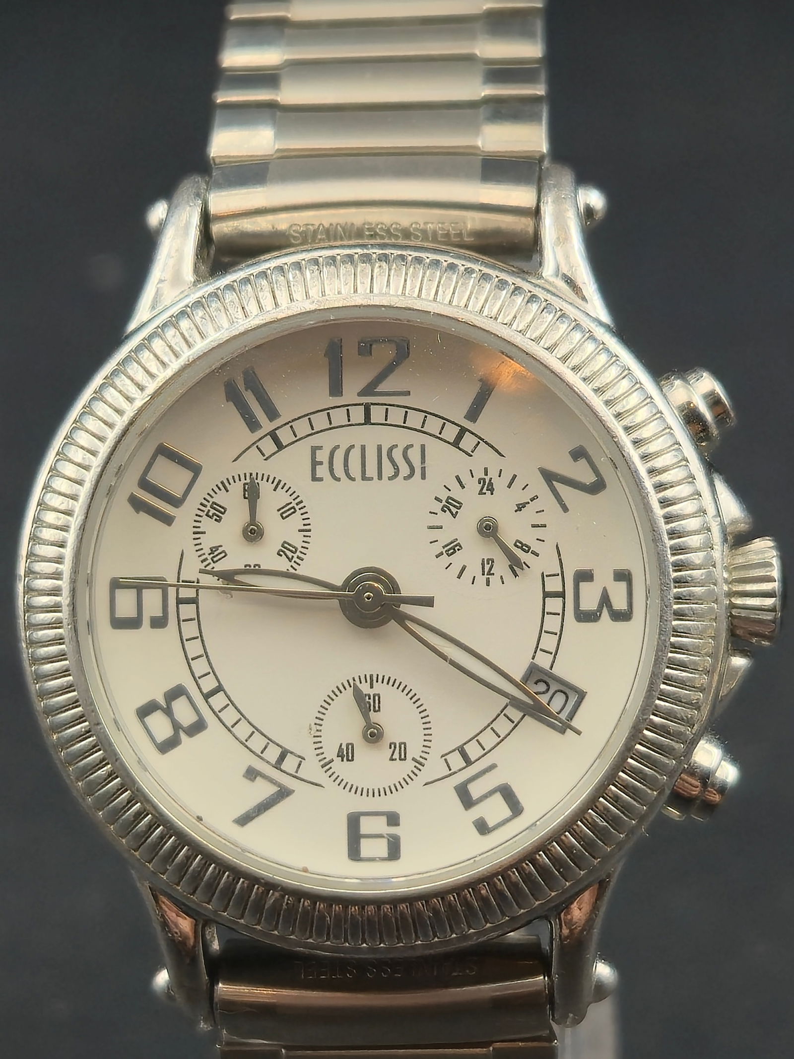 1990s EccLissi Sterling Silver Quartz Chronograph White Dial 35mm Untested: Vintage EccLissi quartz chronograph wristwatch with a white dial and applied Arabic numerals. Dial features three sub-dials and a framed date window at 4. Case is marked sterling silver (.925) with a