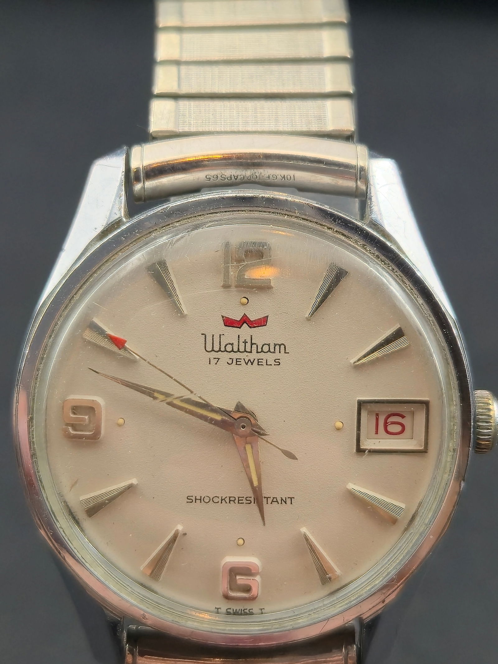 Waltham Swiss 17J Manual Wind Stainless Steel Watch Circa 1960s: Vintage Waltham Swiss wristwatch featuring a silver/off-white dial with applied hour markers and a framed date window at 3 o’clock. The watch is fitted with a stainless steel expansion bracelet and