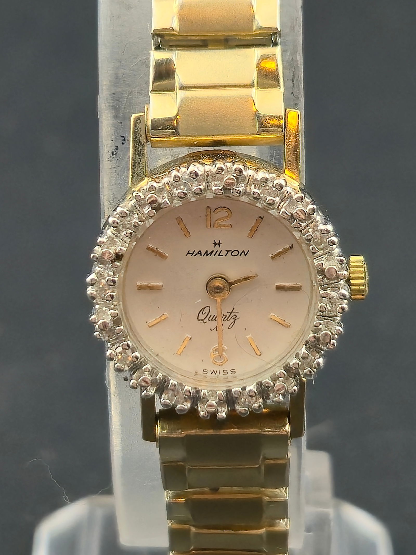 1980s Hamilton Ladies Quartz Wristwatch 10K Gold Filled 18mm: Vintage Hamilton ladies Swiss quartz wristwatch featuring a white dial with applied baton hour markers and signed Hamilton beneath 12.The case is 10K gold filled with a decorative faceted bezel (textu