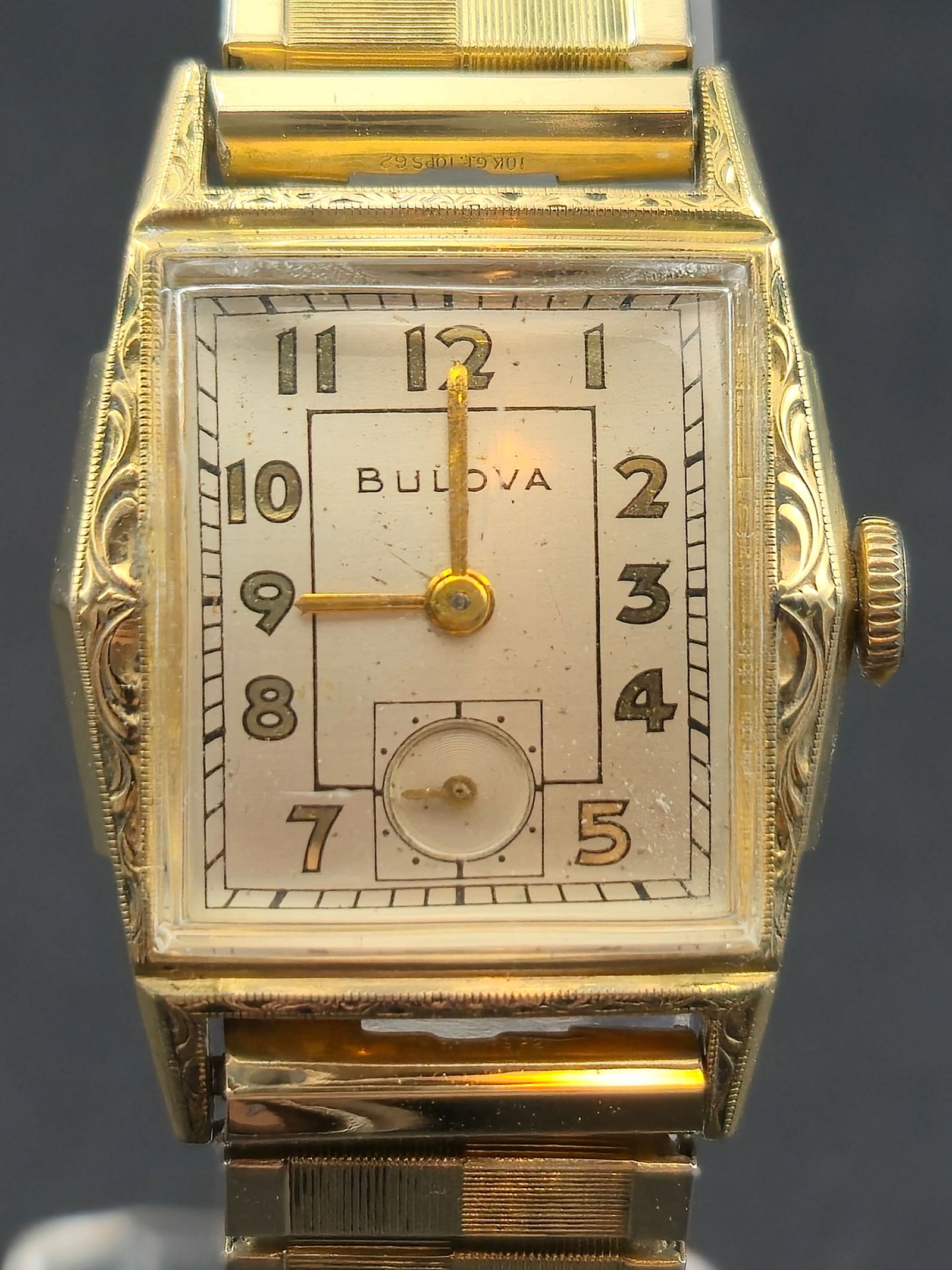 1945 Bulova 10K RGP Bezel Rectangular 10BM 17J Running: Vintage Bulova rectangular wristwatch featuring a cream/white dial with Arabic numerals and a small seconds subdial at 6. Case is stamped Bulova and marked 10K Rolled Gold Plate Bezel with Stainless B