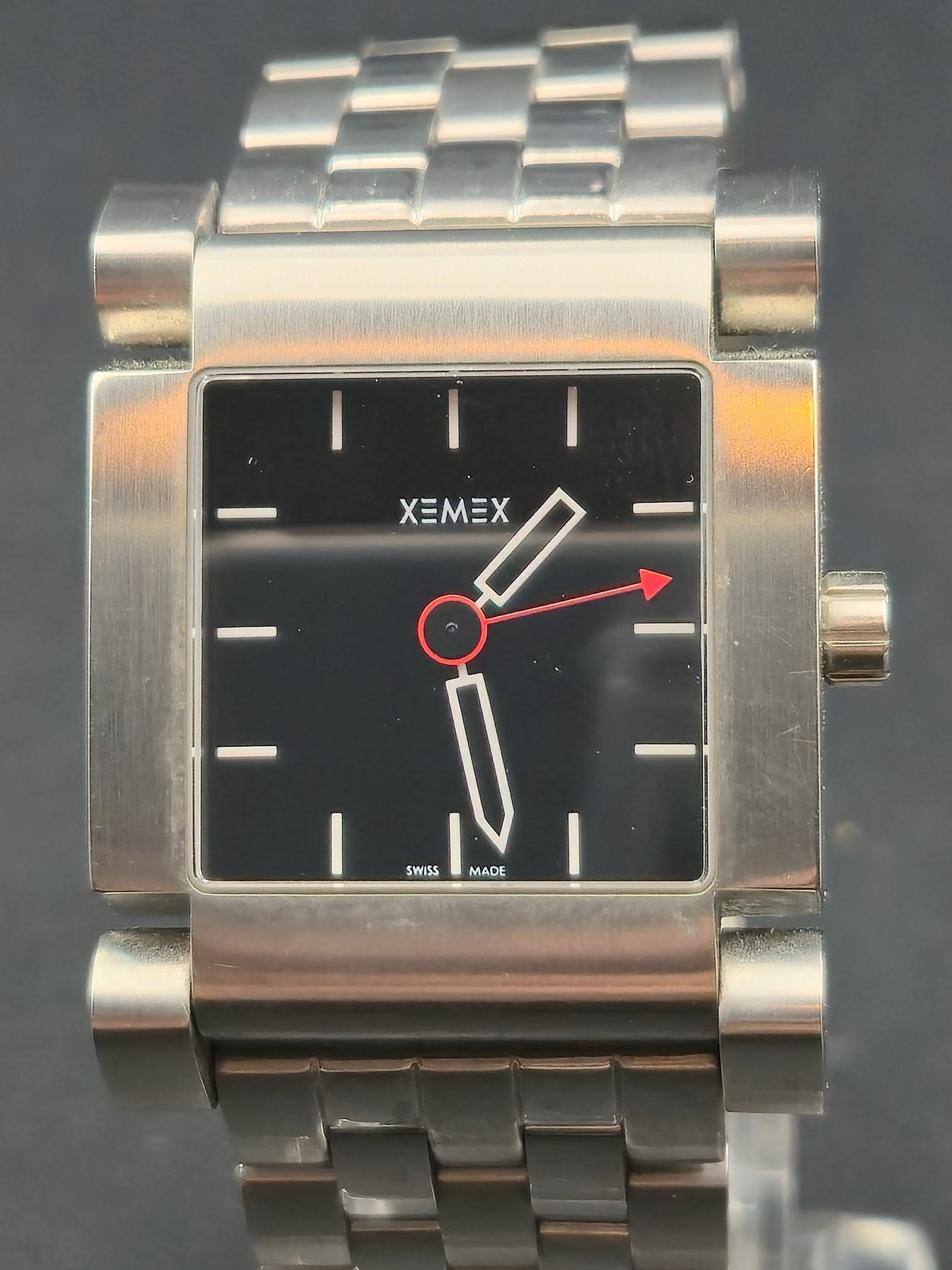 Xemex Swiss Made Automatic Stainless Steel Square Watch Black Dial Bracelet Running: Swiss Made Xemex square wristwatch with black dial and minimalist baton hour markers. Stainless steel case and matching stainless steel bracelet with signed clasp. Exhibition caseback shows an automat