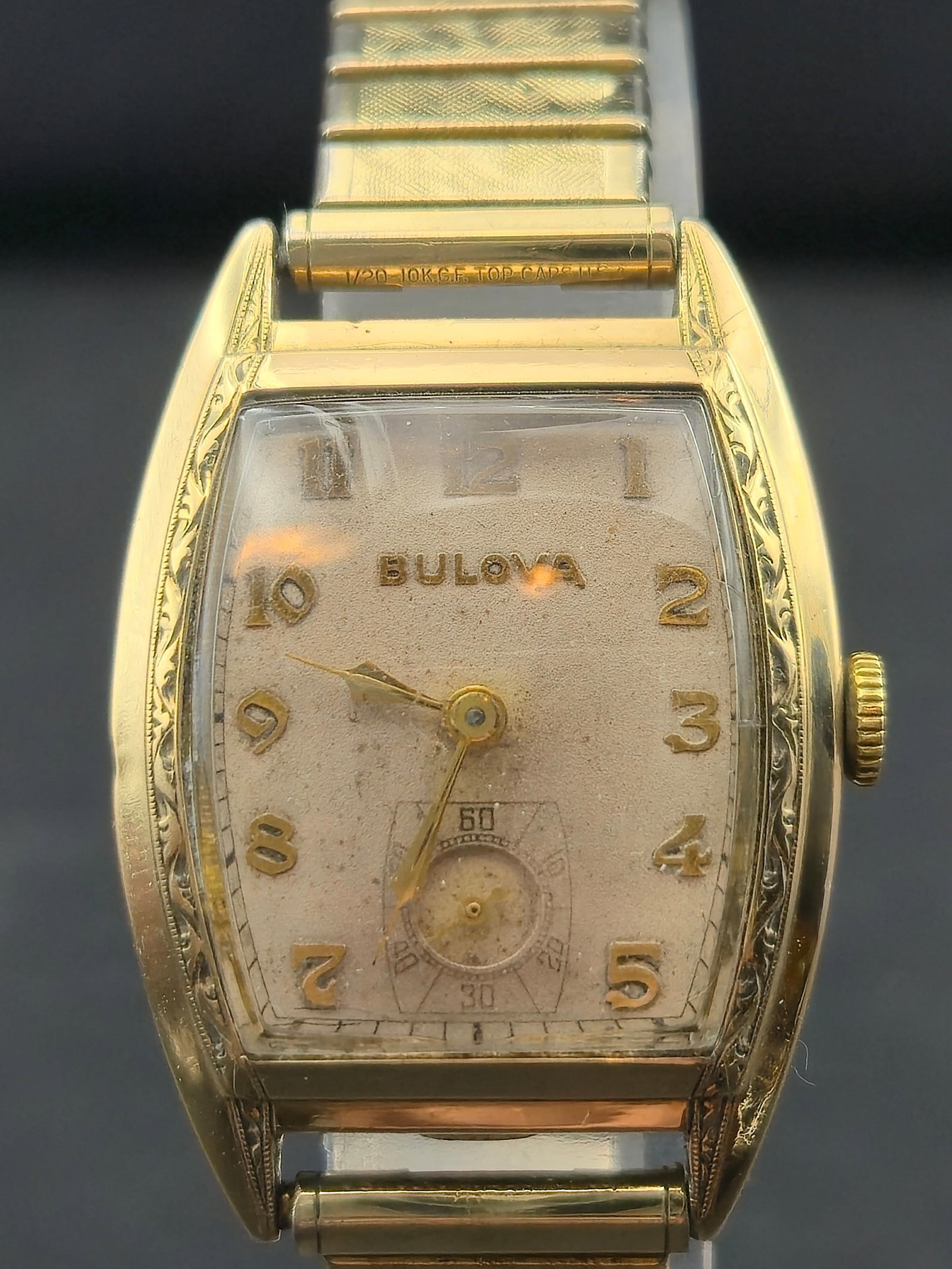 1940s Bulova Tonneau 10K RGP Bezel GF Cap Sterling Base 26mm Running: Vintage Bulova tonneau shaped wristwatch with silver dial and applied gold Arabic numerals. Sub seconds at 6. Case marked inside Bulova 10K Rolled Gold Plate Bezel Sterling Base Stainless Back New Yor