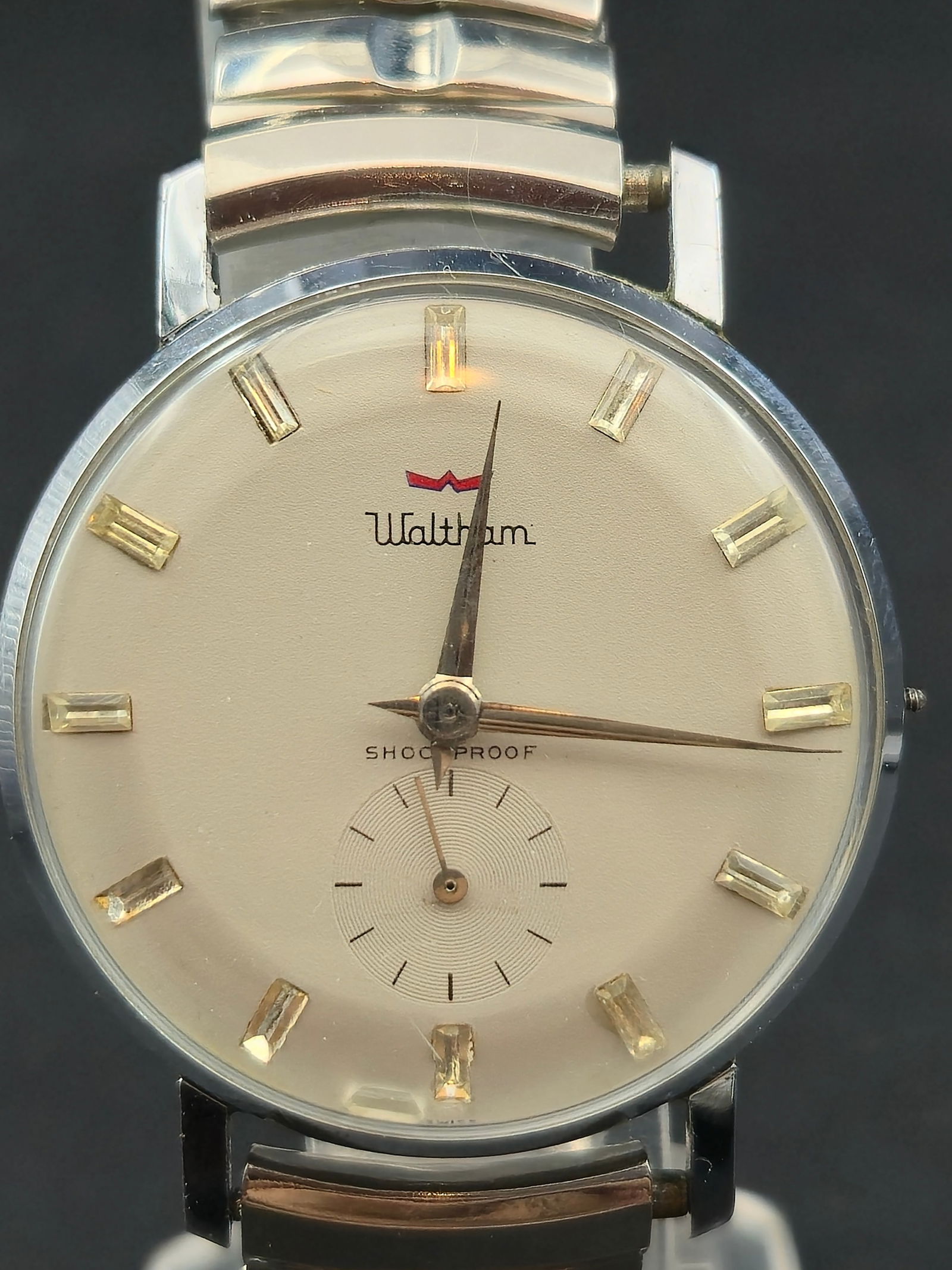 Waltham 7 Jewel Shockproof Sub Seconds 34mm Swiss Case Missing Crown 1960s: Vintage Waltham manual wind wristwatch featuring a clean silver dial with applied baton markers and sub-seconds at 6. Dial signed Waltham and Shockproof.Movement signed Waltham Watch Co, Seven 7 Jewel
