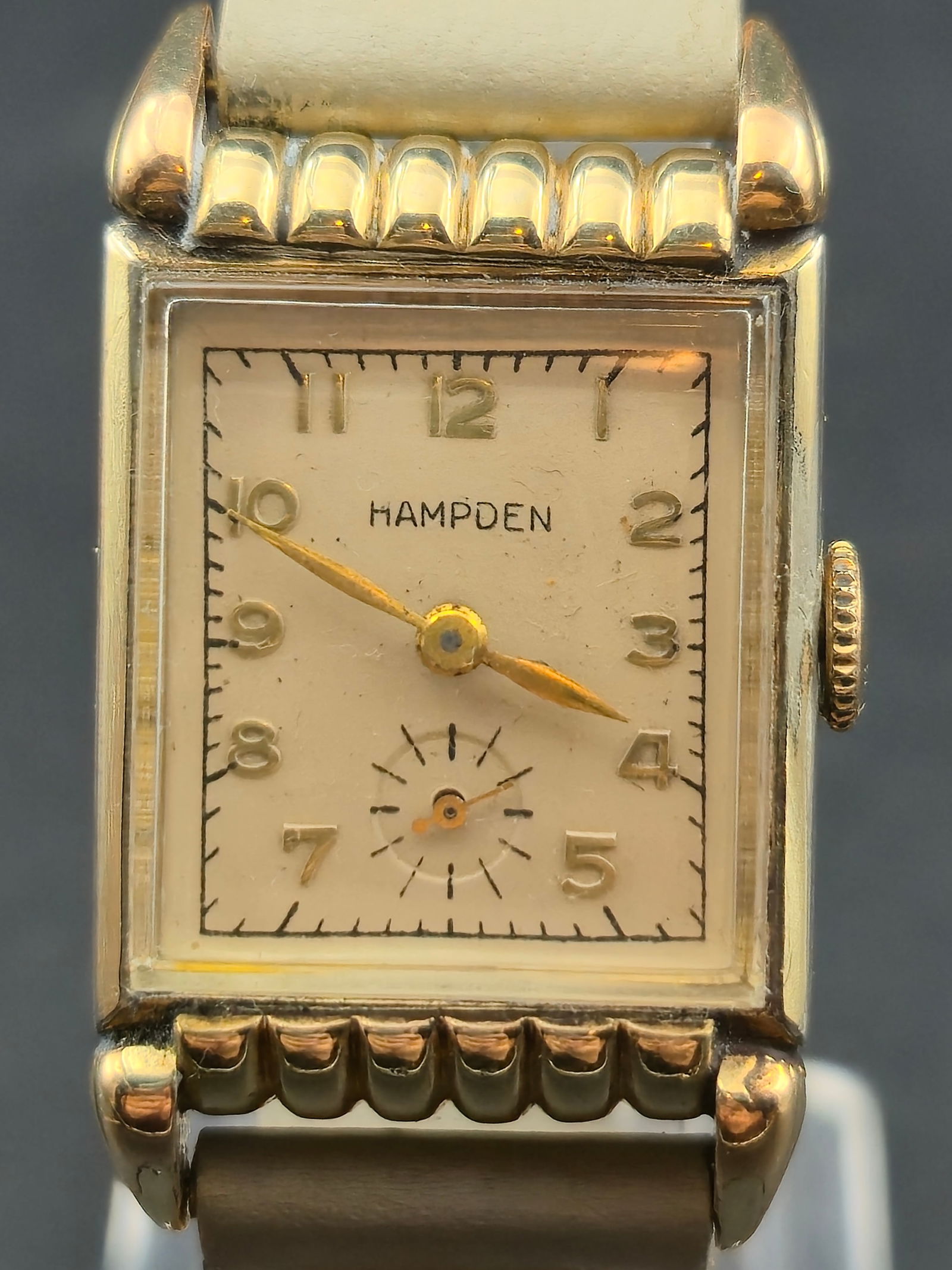 1940s Hampden 10K RGP Tank 17J Manual 21mm Art Deco: 1940s Hampden rectangular Art Deco wristwatch. Case marked 10K RGP bezel stainless steel back. Classic stepped and ribbed lug design with decorative top and bottom elements. Cream dial with applied Ar