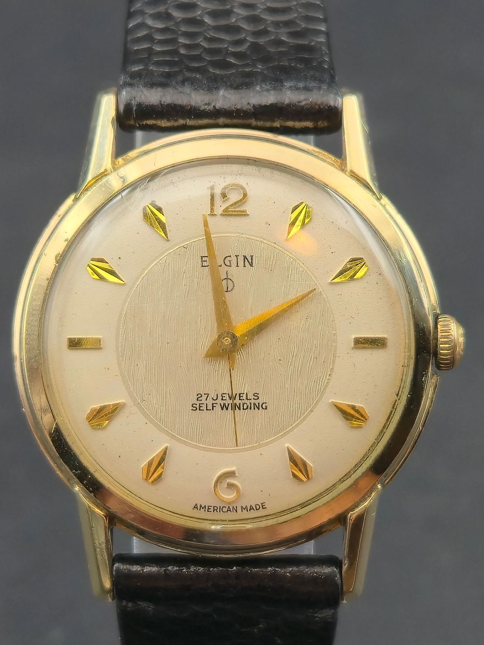 1960 Elgin 761 27J Selfwinding 33mm 10K Rolled Gold Plate Runs: Vintage Elgin automatic wristwatch featuring the Elgin 761 caliber.Dial signed:Elgin27 JewelsSelfwindingAmerican MadeCream dial with textured center panel and applied faceted gold markers.Gold hands.�