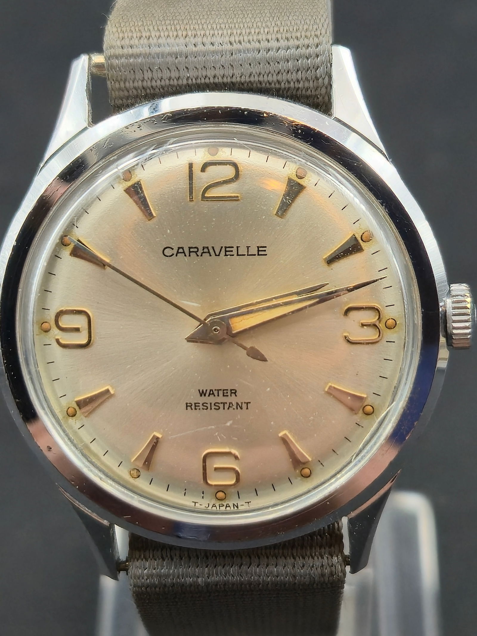 1971 Caravelle 11DP 17J 33mm Japan Water Resistant Running: 1971 Caravelle manual wind wristwatch with silver sunburst dial and applied Arabic numerals at 12, 3, 6, and 9. Dial signed Caravelle Water Resistant T Japan T.Movement marked Caravelle Watch Seventee