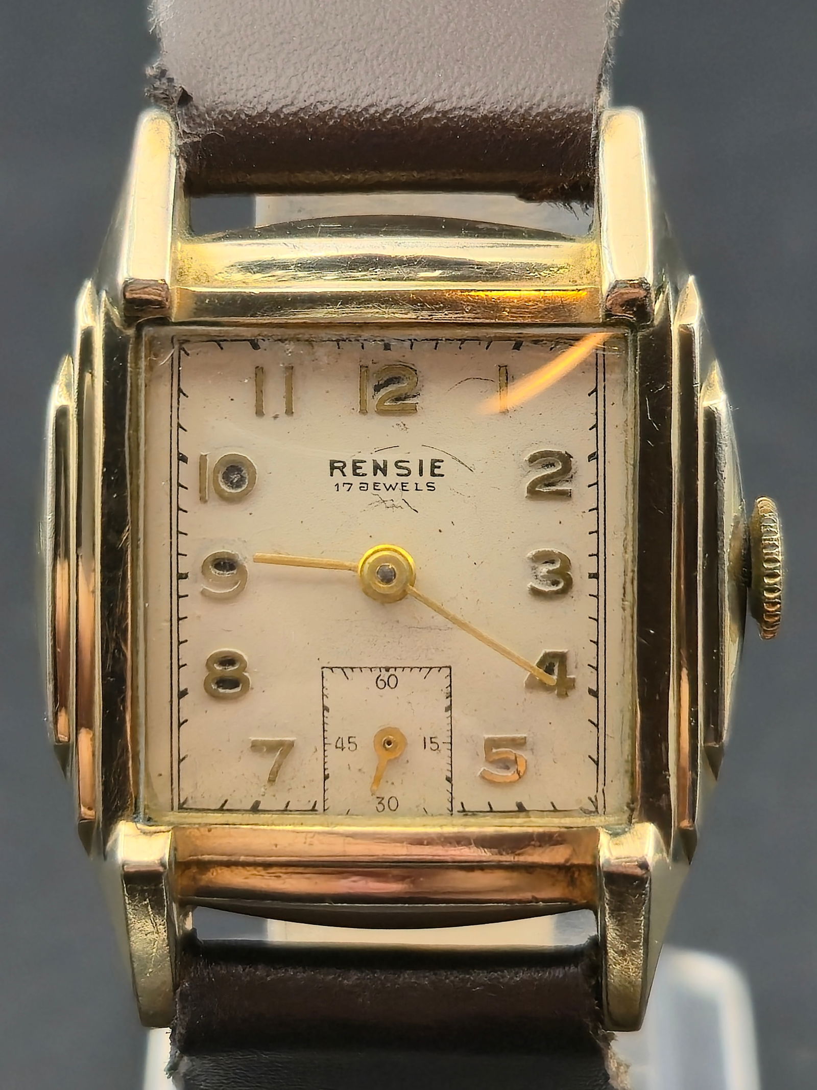 1940s Rensie 17J 10K Gold Filled Rectangular 27mm Sub Seconds: Vintage 1940s Rensie rectangular dress watch featuring a cream dial with applied gold Arabic numerals and a recessed small seconds subdial at 6. Signed RENSIE 17 JEWELS. Classic Art Deco style case wi