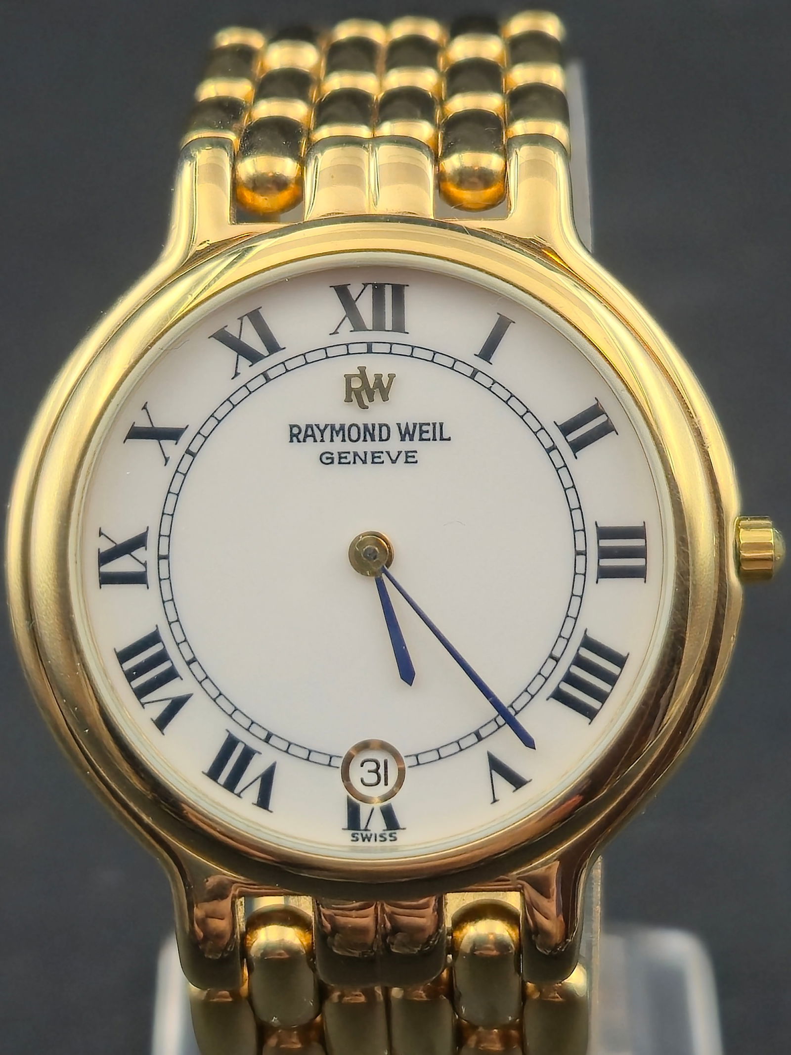 Raymond Weil 9146 32mm Quartz 18K Gold Electroplated Roman Dial Date RW Bracelet Extra Links: Raymond Weil Genève quartz wristwatch, reference 9146. Classic round 18K gold electroplated case with white Roman numeral dial, blued hands, and date window at 6. Caseback marked Raymond Weil 9146, W