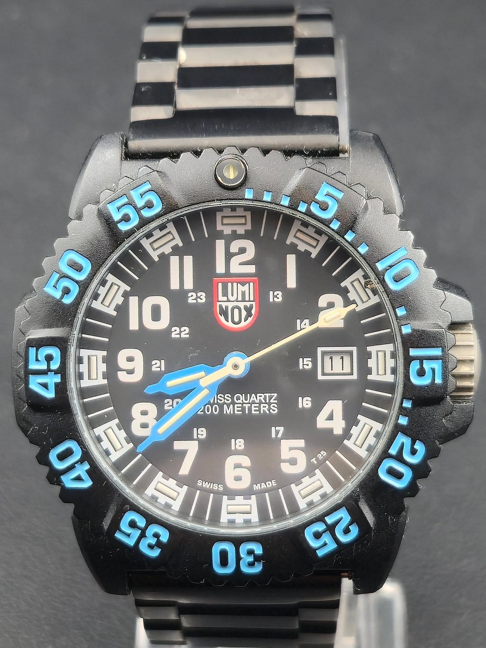 1990s Luminox Navy SEAL Series 3050 44mm PC Carbon 200m Swiss Quartz Date Watch Running New Battery: 1990s Luminox Navy SEAL Series 3050 Swiss quartz dive watch with black dial, blue accented hands, date at 3, and unidirectional rotating bezel with blue numerals. Dial marked Swiss Quartz 200 Meters a