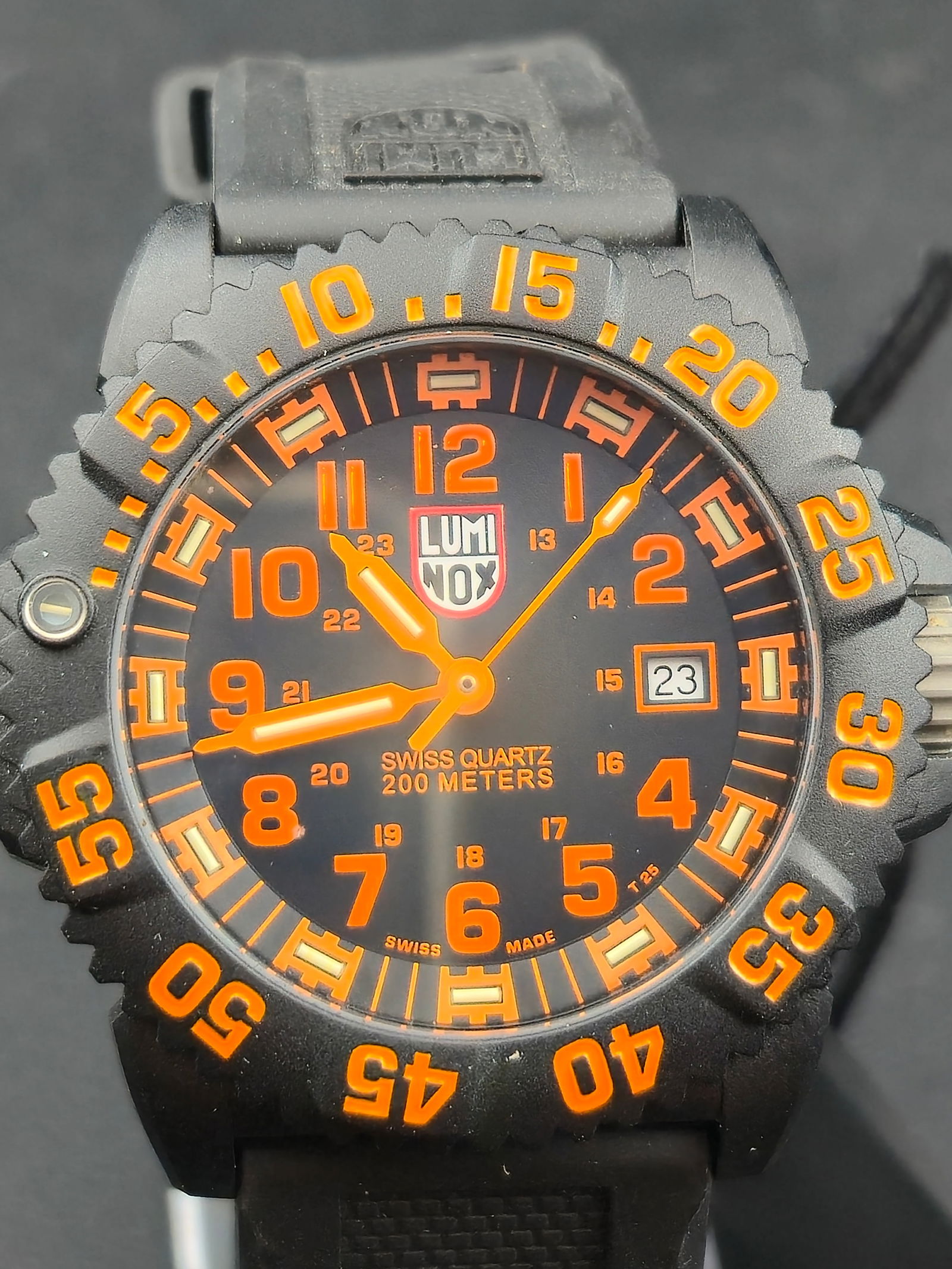 NOS Luminox Navy SEAL Series 3050 43mm 200M Swiss Quartz Black Orange Dial Full Set: New old stock Luminox Navy SEAL Series 3050 Swiss made quartz watch featuring black PC carbon case, black dial with bright orange numerals and hands, and unidirectional rotating bezel. Dial marked Swi