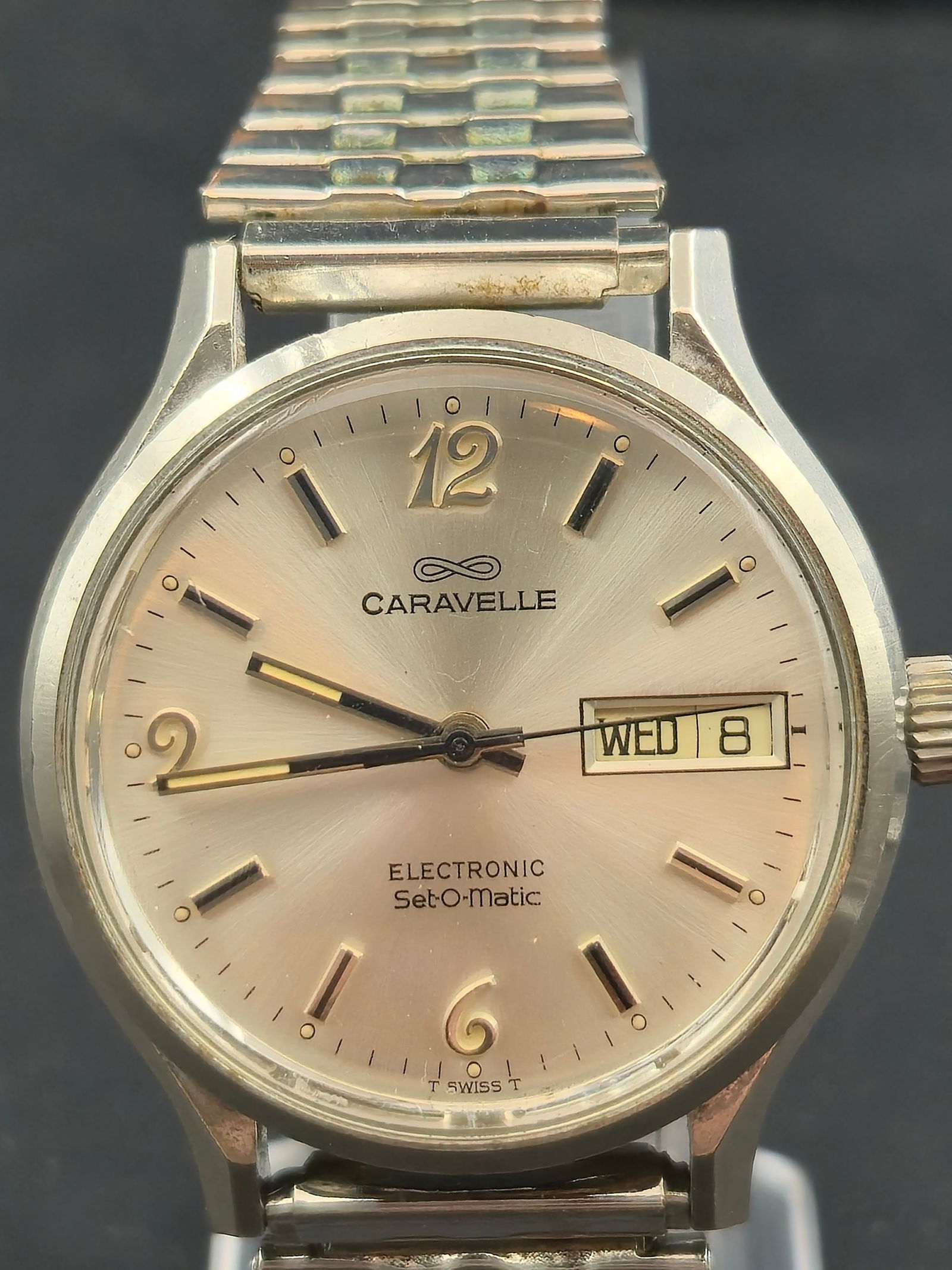Caravelle Electronic Set-O-Matic Day Date Watch 37mm New Battery: Vintage Caravelle wristwatch with silver tone dial signed Caravelle and Electronic Set-O-Matic. The dial features applied hour markers, Arabic numerals at 12, 6, and 9, and a day-date window at the 3