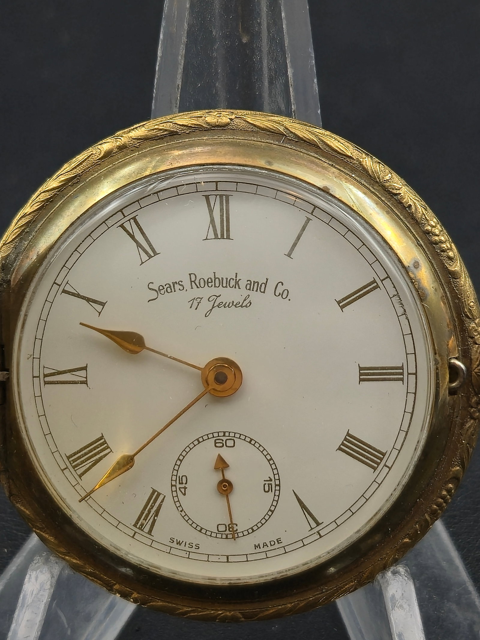Circa 1930s Sears Roebuck 17 Jewel Swiss Pocket Watch Gold Tone Hunter Case 47mm Running: Vintage pocket watch signed Sears Roebuck and Co – 17 Jewels with a clean white dial featuring Roman numerals and a sub-seconds register at 6. The dial is marked Swiss Made.The movement is stamped A