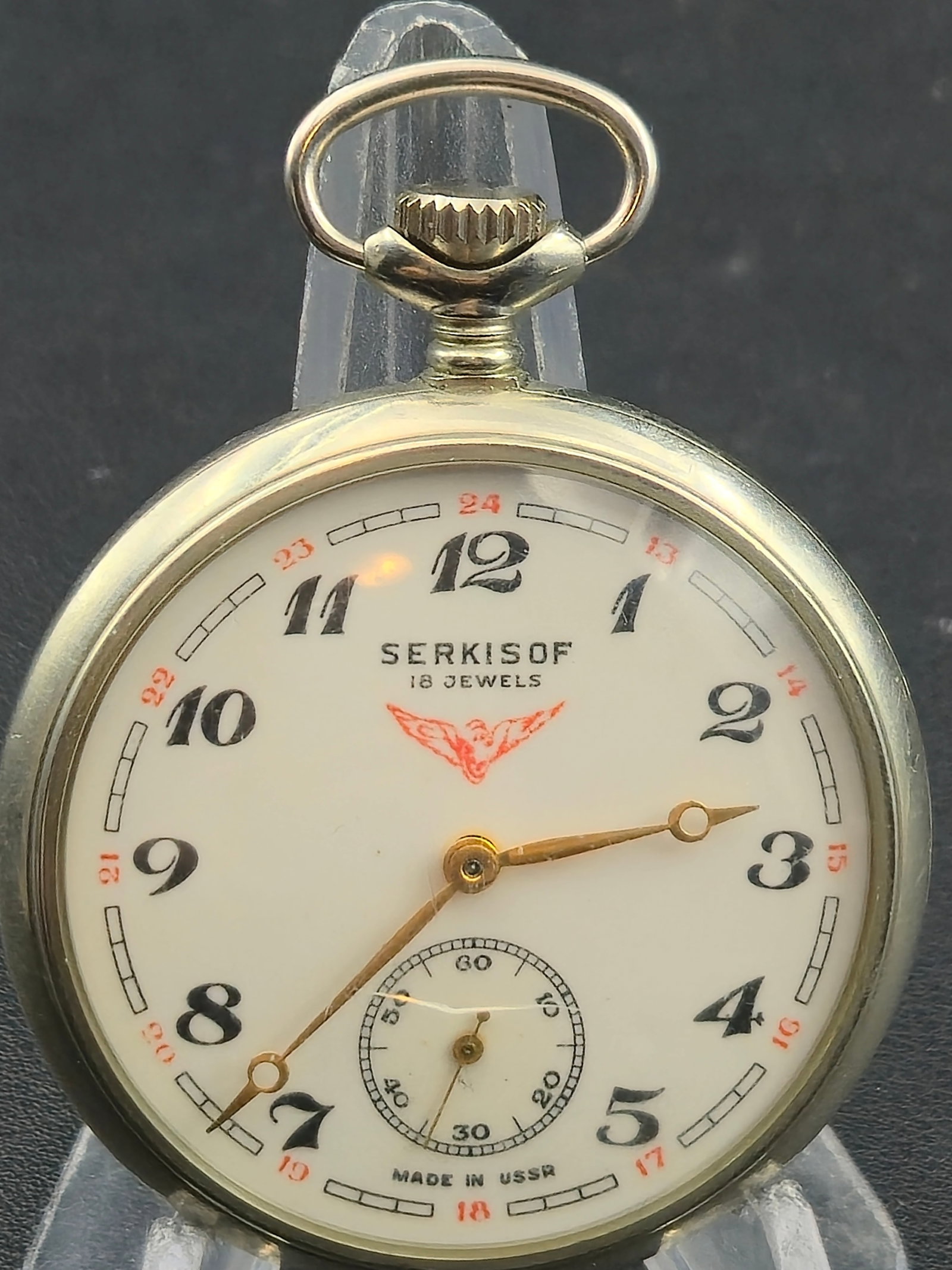 Circa 1960s Serkisof Demiryolu 18 Jewel USSR Pocket Watch Railroad Train Case 49mm Running: Vintage Soviet pocket watch signed Serkisof – 18 Jewels with a white dial featuring Arabic numerals, red 24-hour inner track, and sub-seconds at 6. The dial is marked Made in USSR.The movement is ma