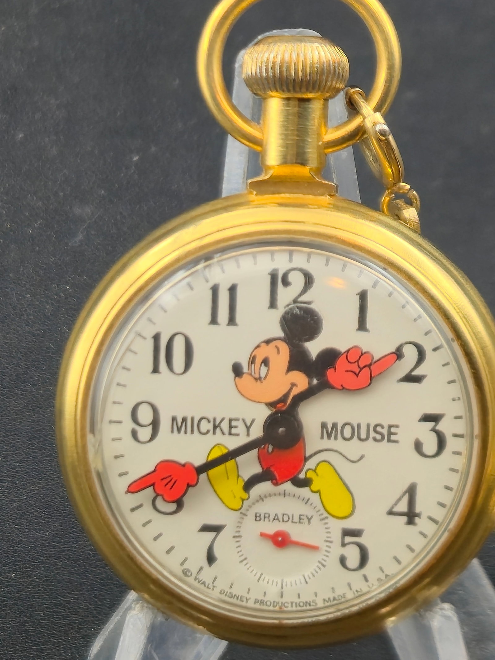 Bradley Mickey Mouse Pocket Watch Train Case w Chain 50mm Mechanical Runs: Vintage Bradley Mickey Mouse pocket watch featuring the iconic character with animated arms serving as the hour and minute hands. The watch is housed in a gold-tone case with an engraved train scene o
