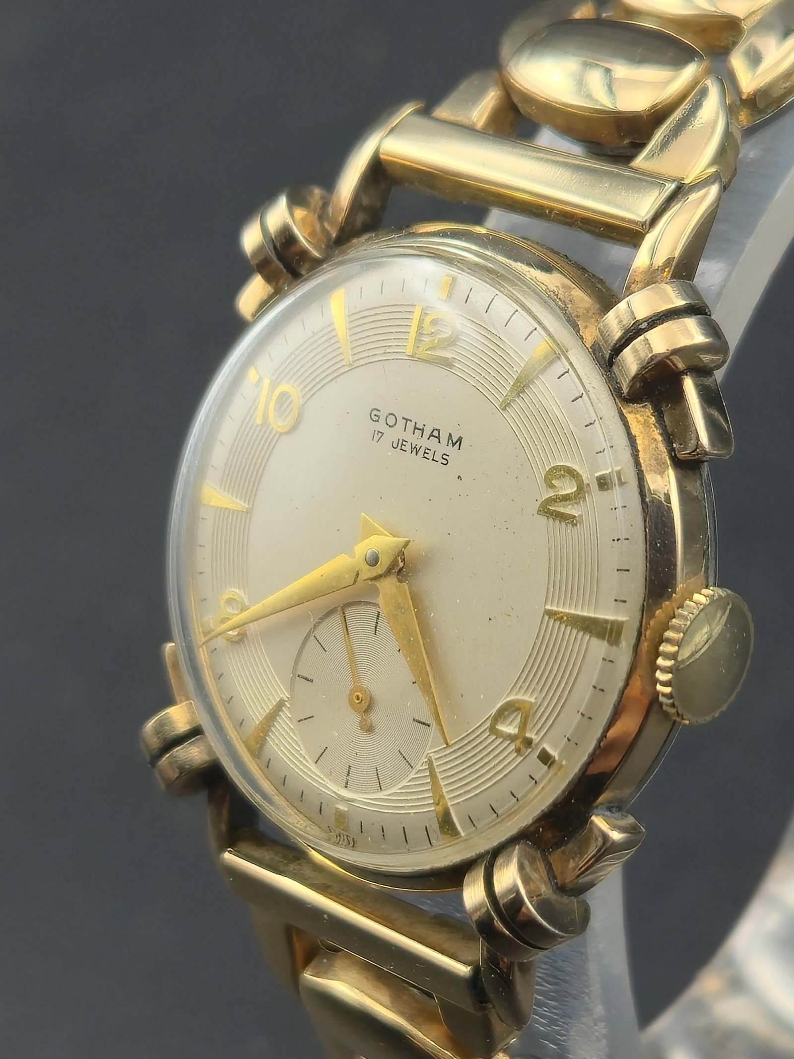 1940s Gotham 17J Swiss Knotted Lugs Gold Filled Wristwatch Running Sub Seconds: Vintage Gotham wristwatch featuring a striking Art Deco case with rare knotted lug design. The dial displays a clean sector-style layout with applied Arabic and dagger markers, paired with a sub-secon