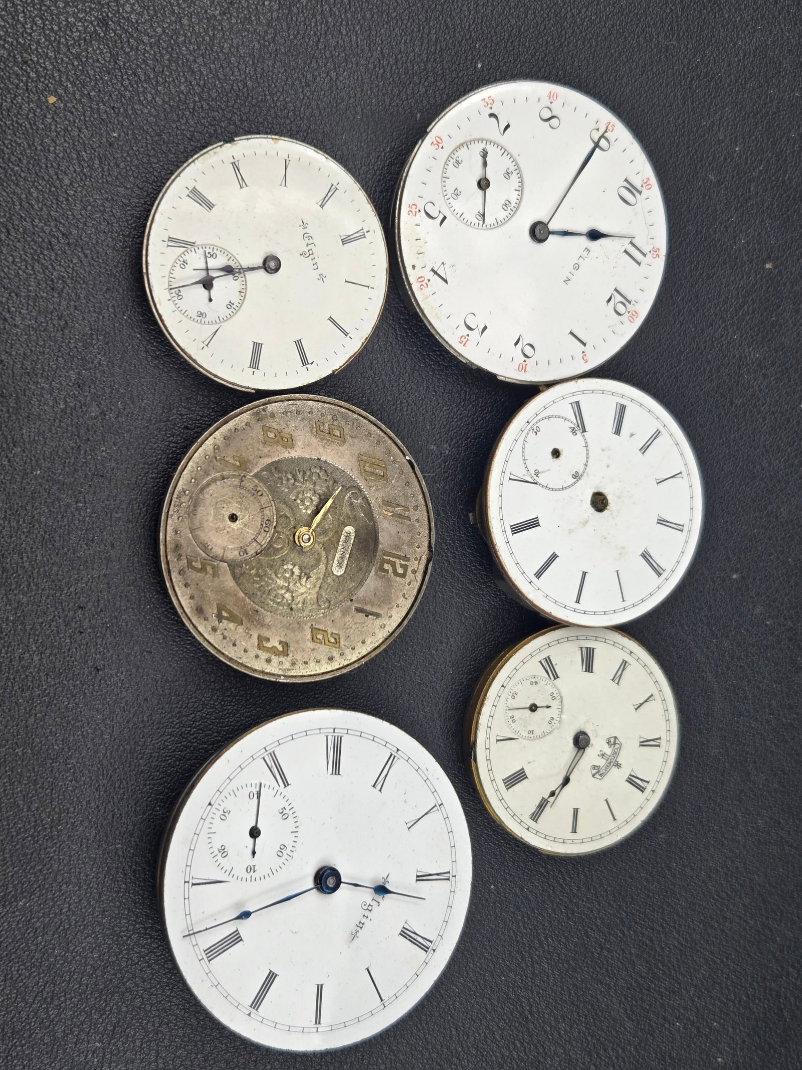 Elgin Pocket Watch Movements & Dials Parts Lot 17J Some Running Enamel Roman Arabic Mixed: Mixed lot of Elgin pocket watch movements and enamel dials including multiple sizes and styles. Visible Elgin-signed movements and dials with both Roman numeral and Arabic numeral configurations, incl